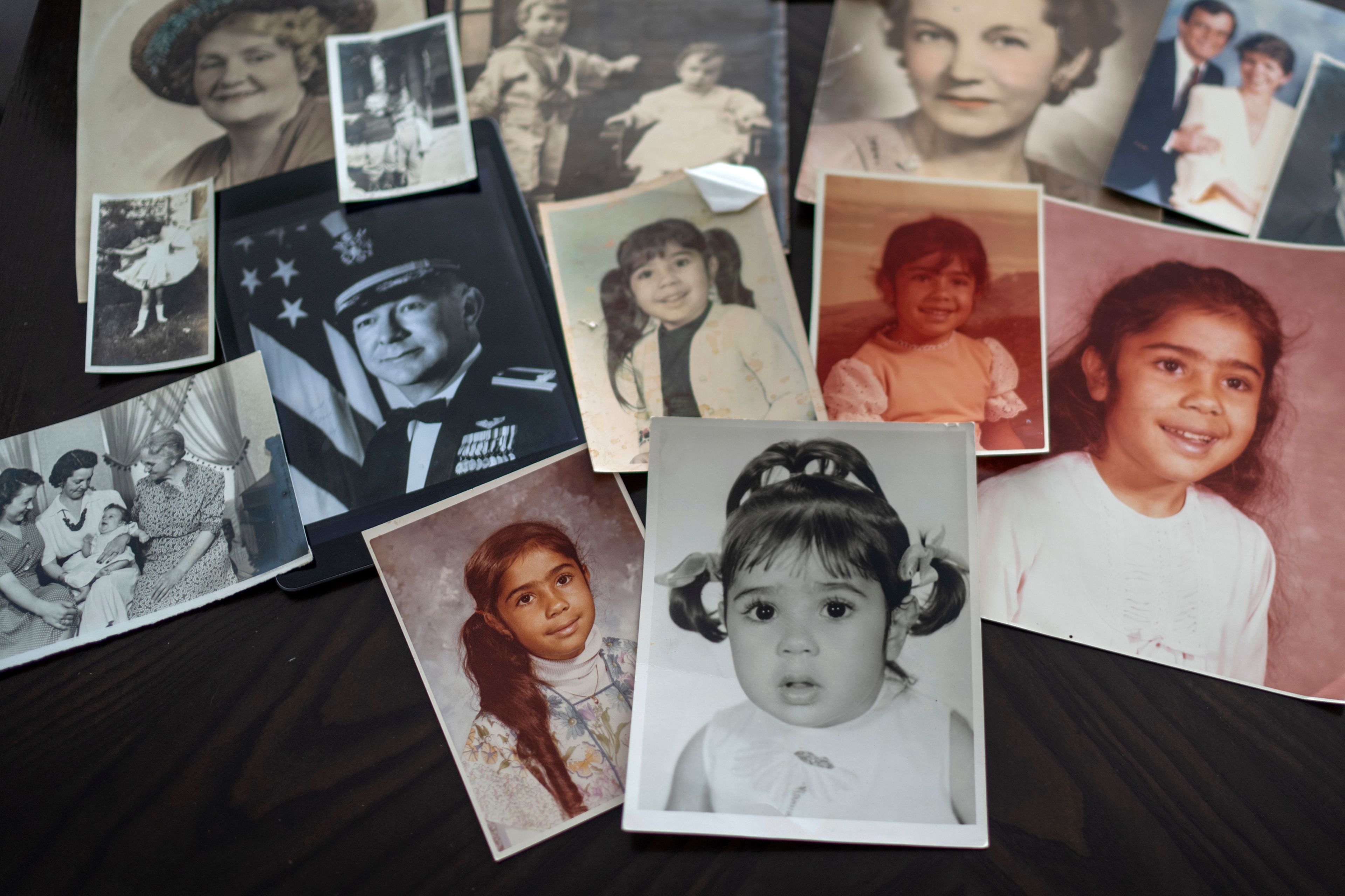 Childhood photos of Buttons are displayed along with a picture of her father, a WWII Air Force veteran, at left, and additional family photos, Monday, June 24, 2024, in Henderson, Nev. "My dad died thinking, 'I raised my daughter. I did my part,' but not knowing it put me on a path of instability and fear," she said. (AP Photo/David Goldman)