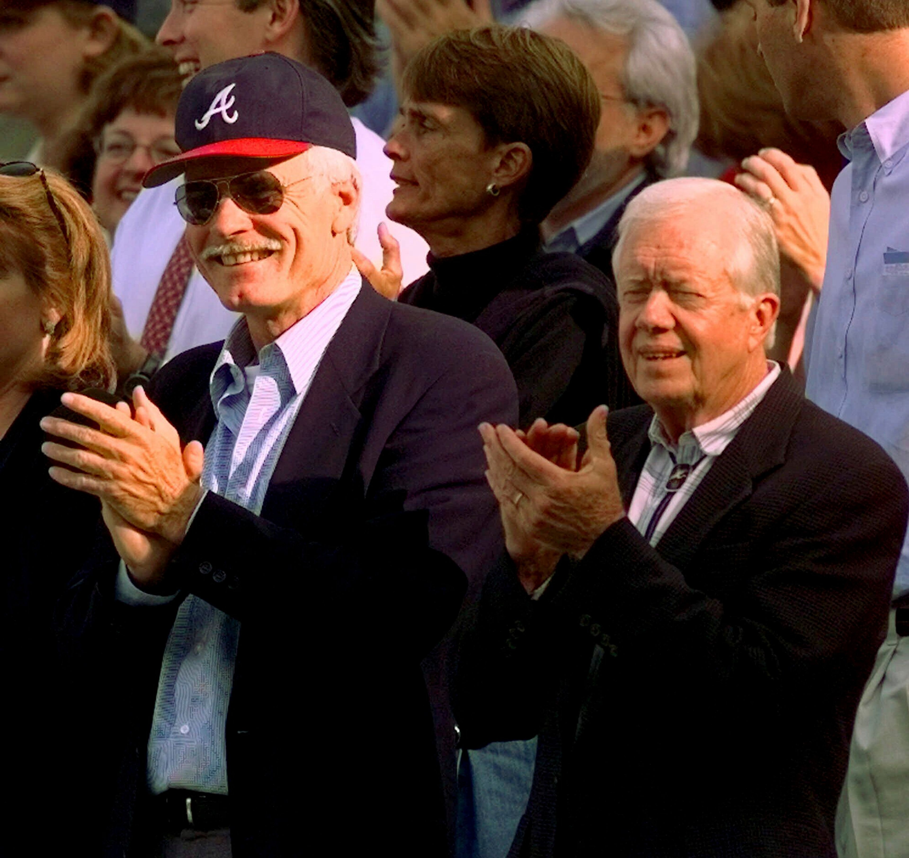 FILE - Former President Jimmy Carter, right, and Atlanta Braves team owner Ted Turner, left, watch early play during Game 6 of the National League Championship Series in Atlanta, Oct. 14, 1998. (AP Photo/Pat Sullivan, File)