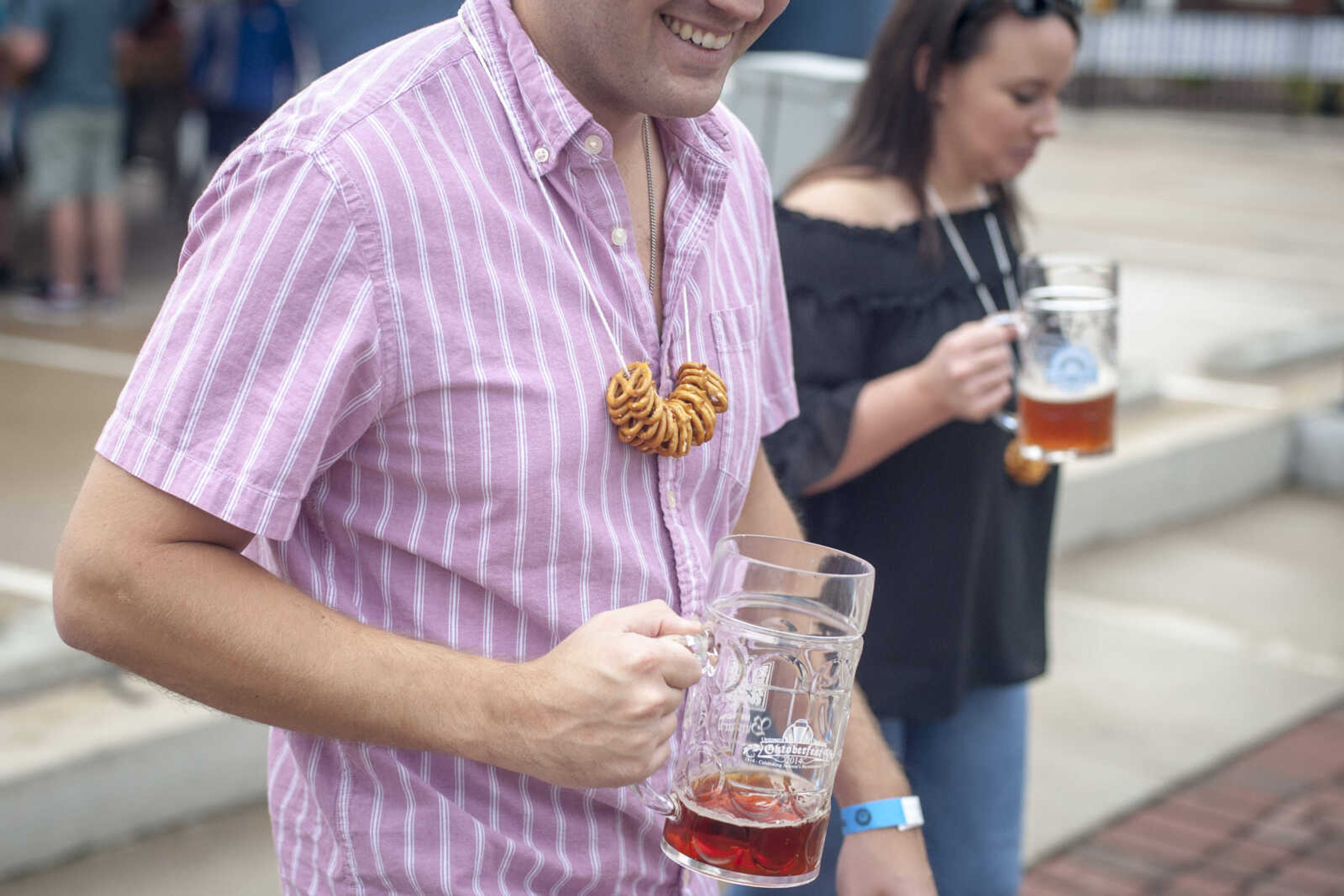 A reveler carries beer and pretzels during Uptown Jackson Oktoberfest Saturday, Oct. 5, 2019, in Uptown Jackson.