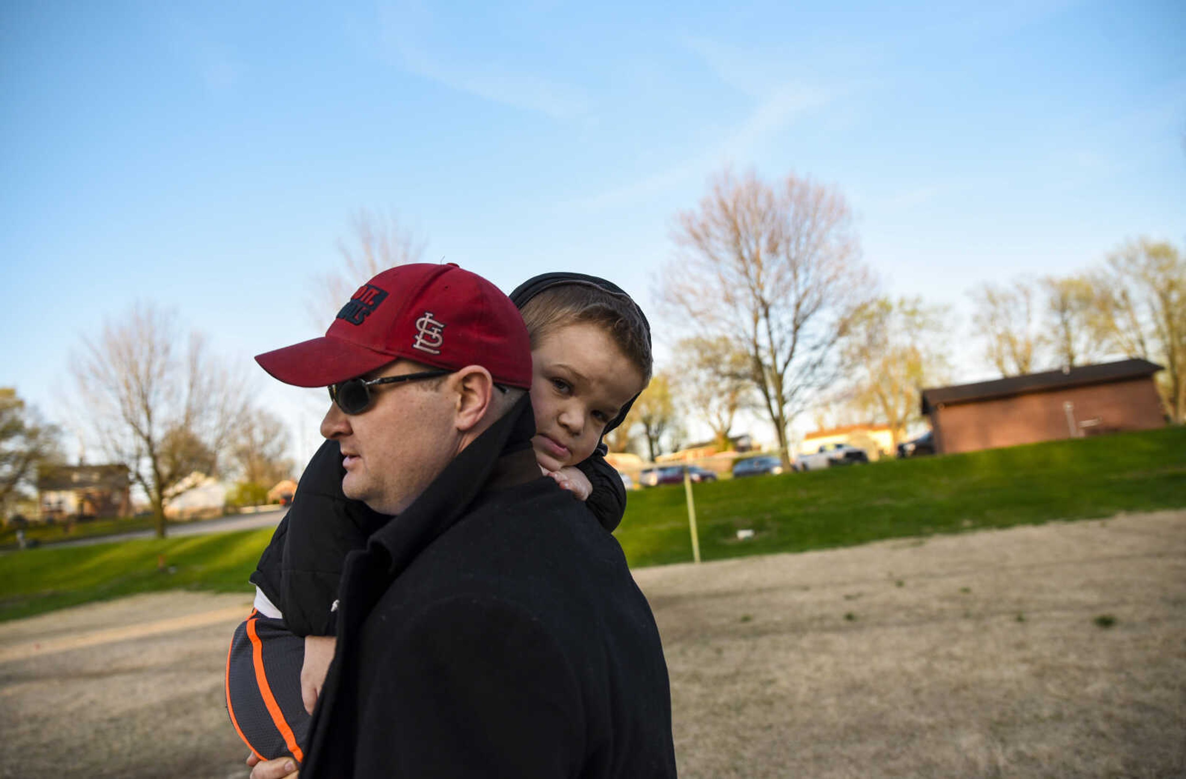 Izaac Pursley is carried by his father Greg Pursley as they make their way back to the car after an evening of recreational flag football April 19, 2018, in Jackson.