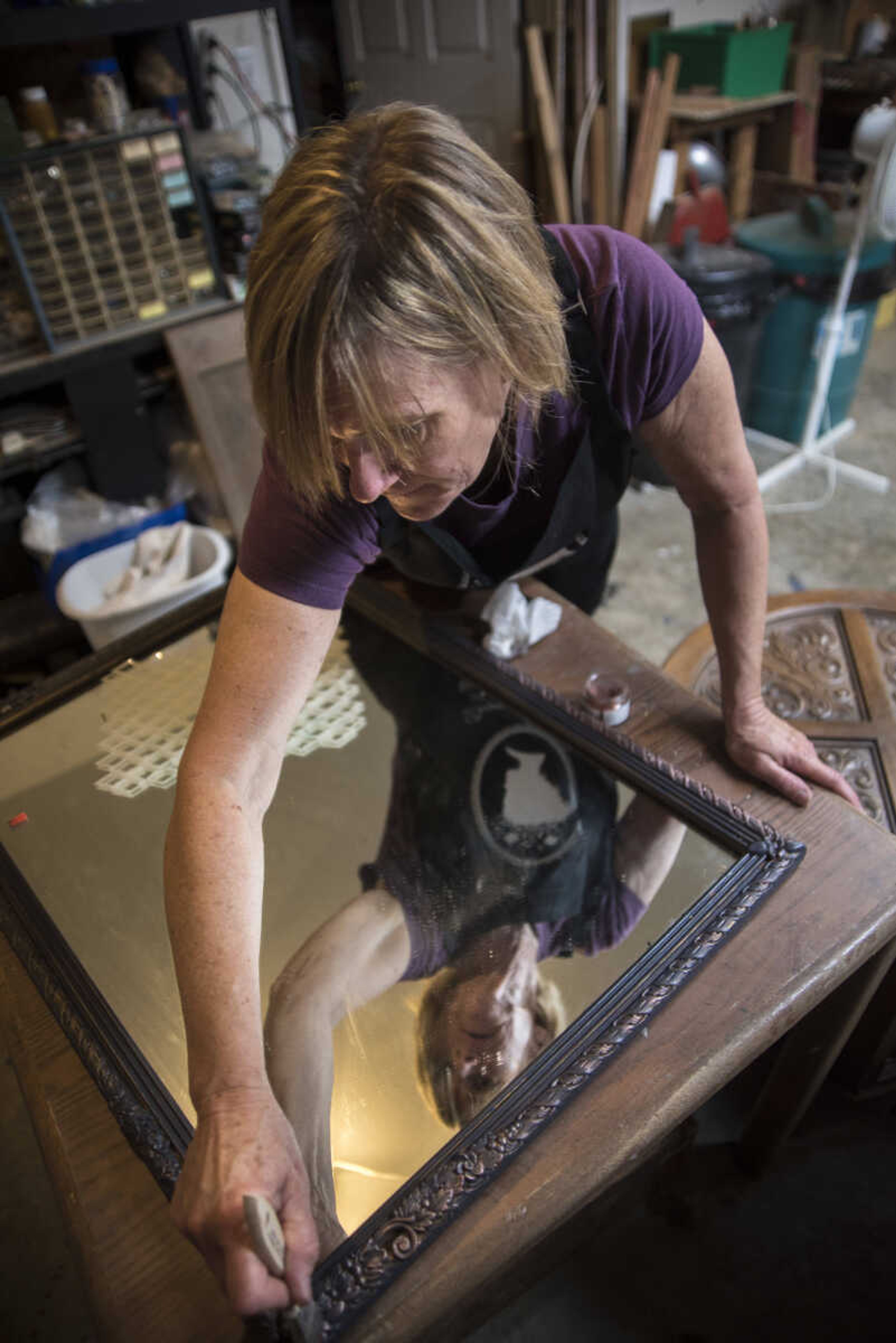 Debbie Birk applies French gilding wax to a mirror she is redesigning, the wax gives a metallic look when used. Birk said she finds furniture and other items everywhere from yardsales, on Sell It Semo or just ion the side of the road.