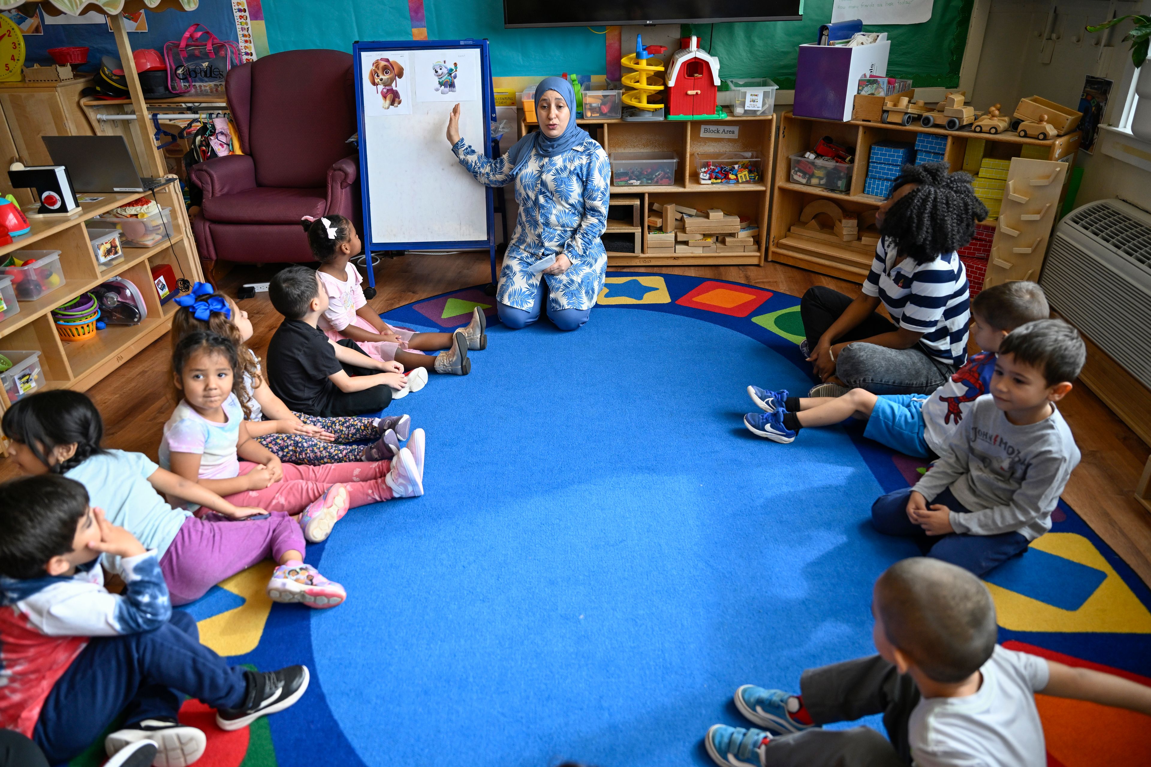 Preschool teacher Tinhinane Meziane, center, instructs to her students on how to vote the most popular character of the TV show PAW Patrol at the ACCA Child Development Center, Thursday, Sept. 19, 2024, in Annandale, Va. The students are getting foundational lessons on how to live in a democracy by allowing them to regularly vote on different things through out the day. (AP Photo/John McDonnell)