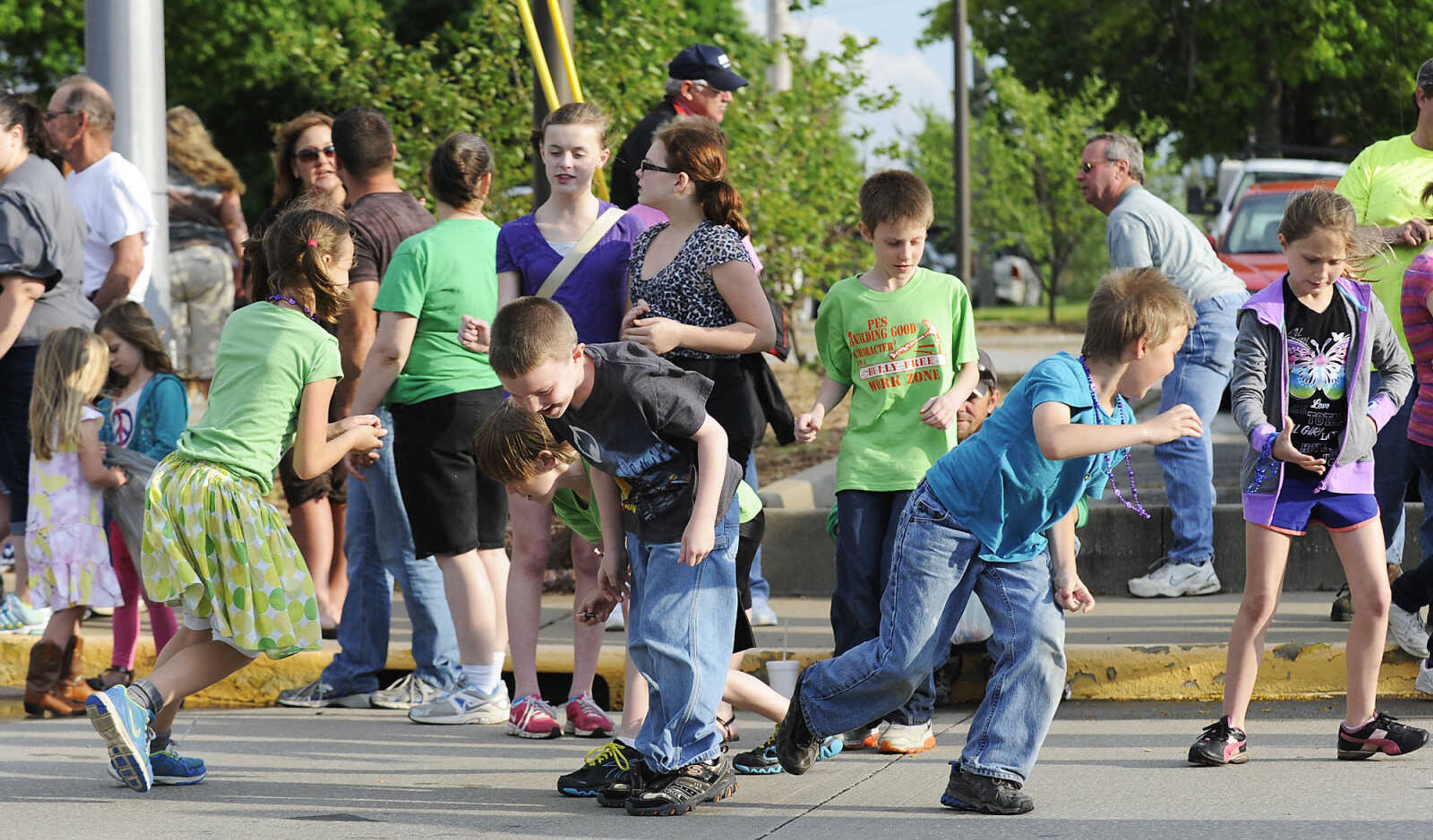 Children scramble for candy during the Perryville Mayfest Parade Friday, May 10, in Perryville, Mo. This year's Mayfest theme is Peace, Love, Perryville Mayfest.