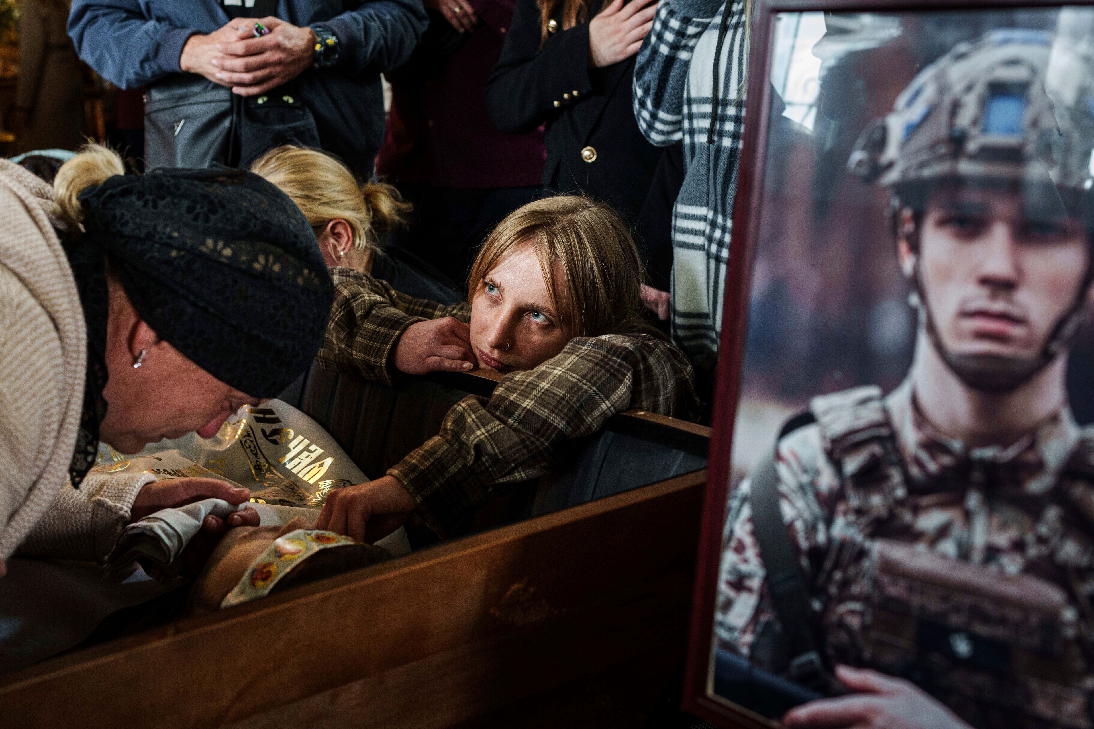 Relatives cry over the coffin of Ihor Kusochek, Ukrainian soldier of the Azov brigade who was killed at the frontline in Toretsk, during his funeral ceremony in Bobrovytsia, Chernihiv region, Ukraine, Friday Oct. 4, 2024. (AP Photo/Evgeniy Maloletka)