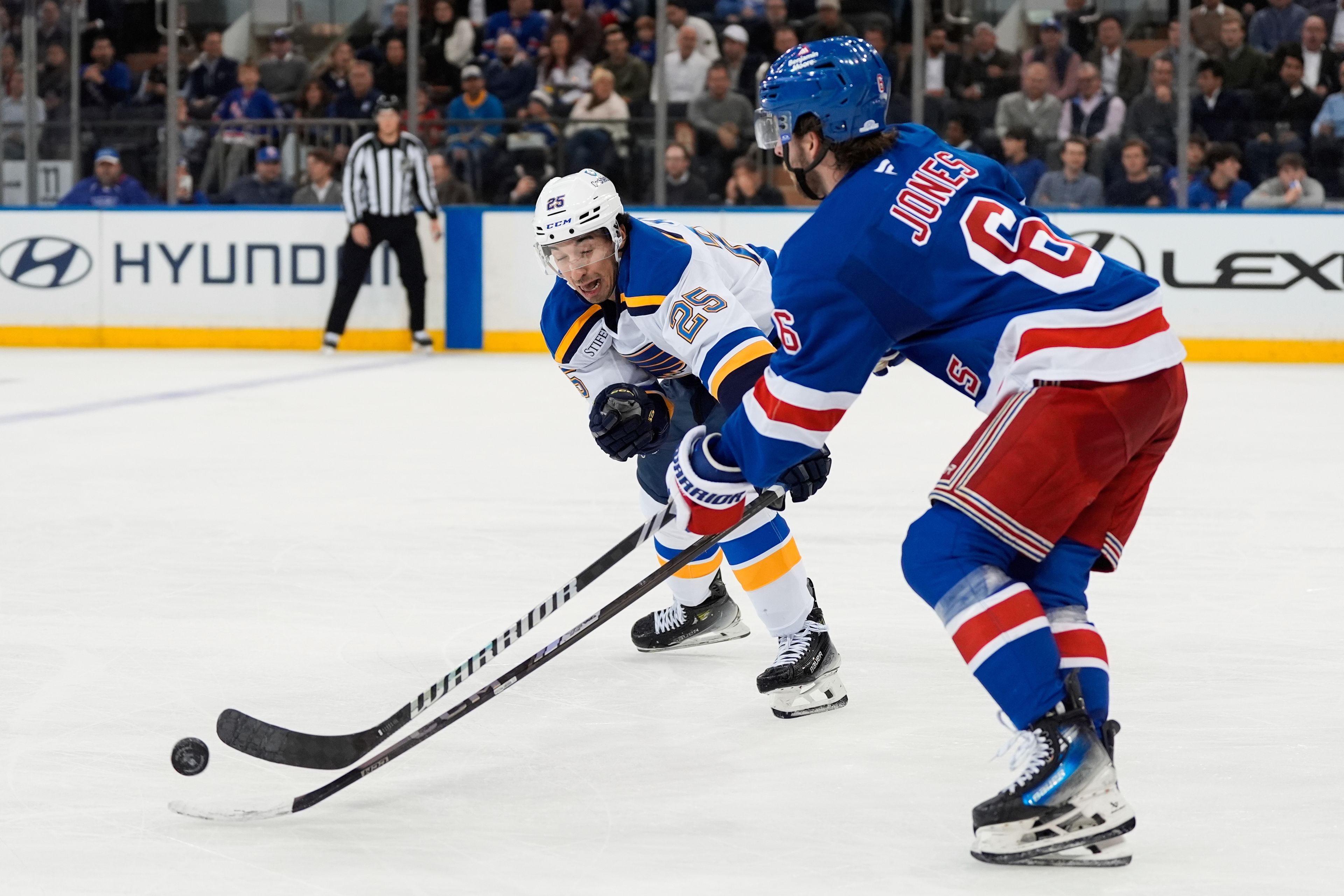 St. Louis Blues center Jordan Kyrou (25) and New York Rangers defenseman Zac Jones (6) fight for the puck during the second period of an NHL hockey game, Monday, Nov. 25, 2024, in New York. (AP Photo/Julia Demaree Nikhinson)