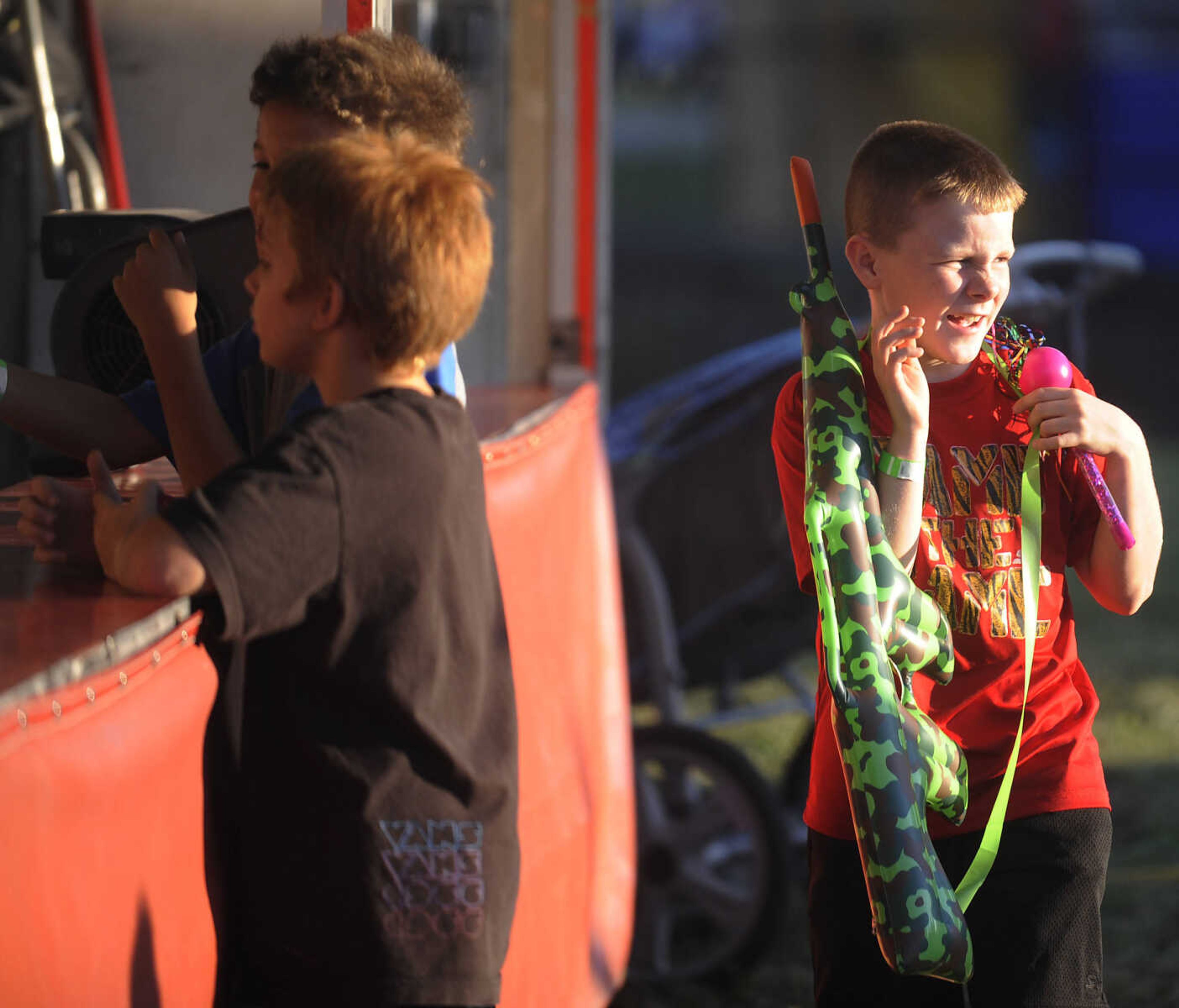 Bryce Horrell, 10, right, slings his prize over his shoulder after playing the beach ball toss with friends Diondre Wiggins, 10, far, and Ethan Rider, 9, near, during Chaffee's Annual German Days Festival Friday, August 10, at Frisco Park.