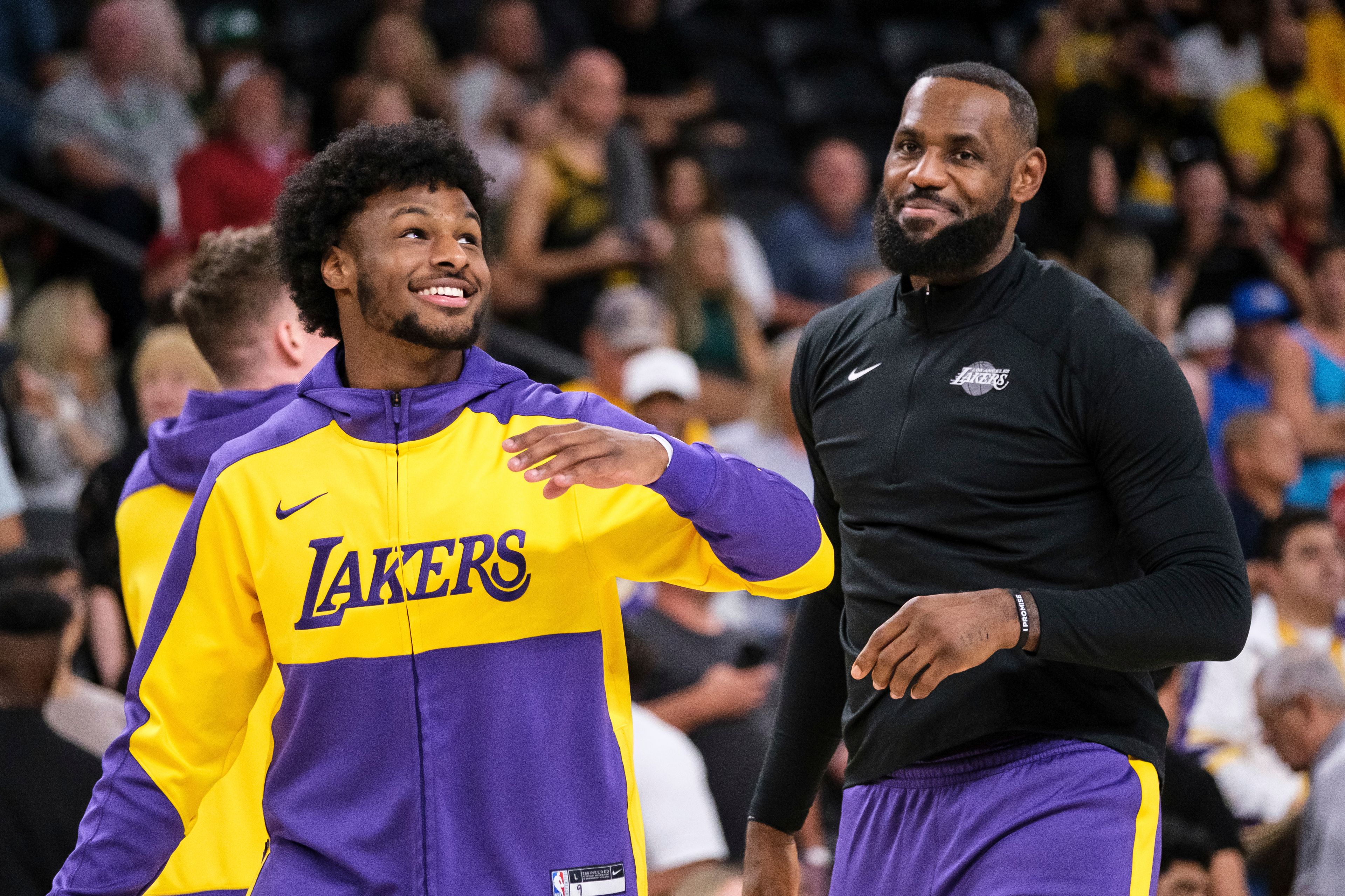 FILE - Los Angeles Lakers guard Bronny James, left, and forward LeBron James warm up before a preseason NBA basketball game against the Phoenix Suns, Sunday, Oct. 6, 2024, in Palm Desert, Calif. (AP Photo/William Liang, File)