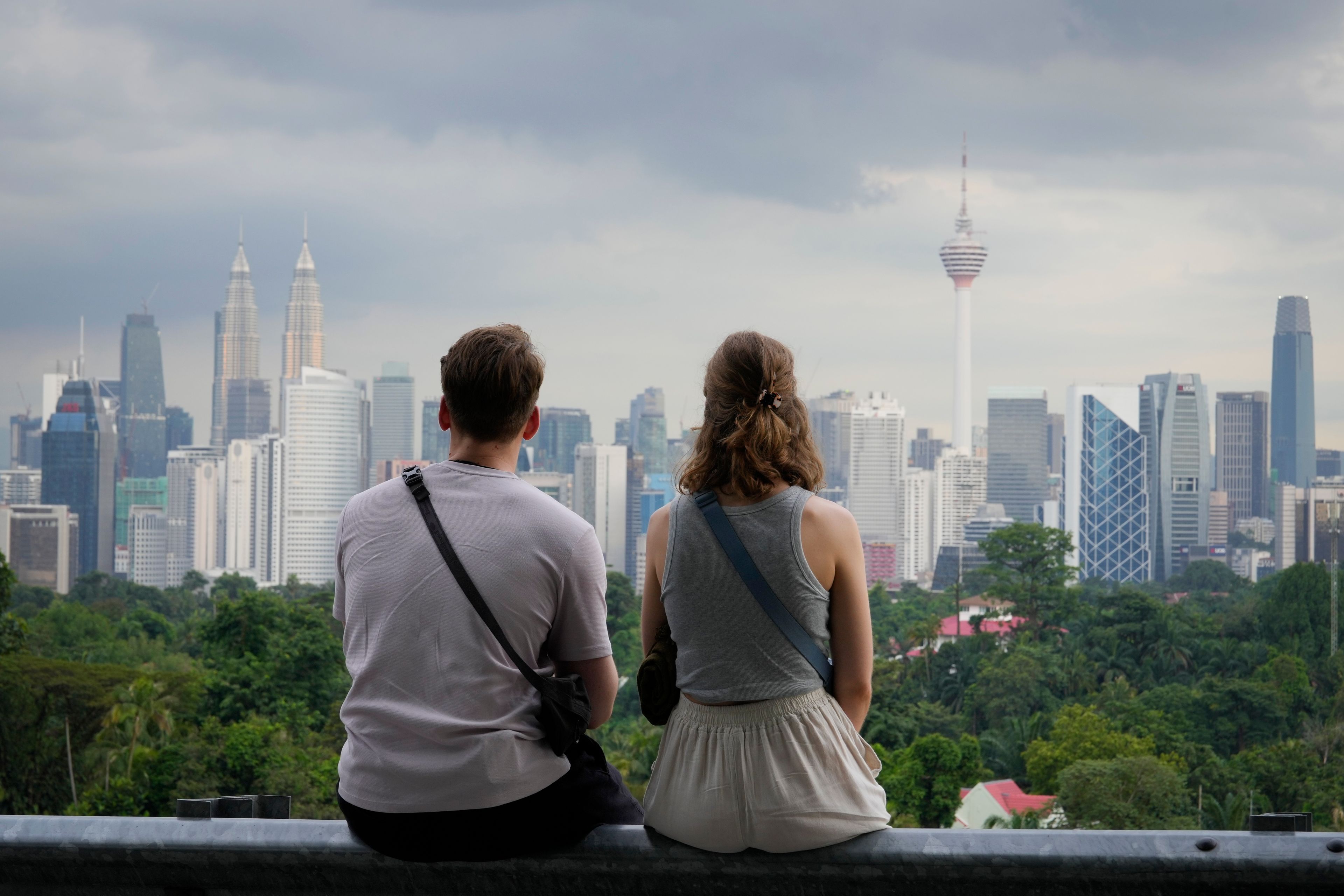 A couple enjoy the view of Kuala Lumpur city skyline at a popular viewing area in Kuala Lumpur, Malaysia, Wednesday, Sept. 18, 2024. (AP Photo/Vincent Thian)