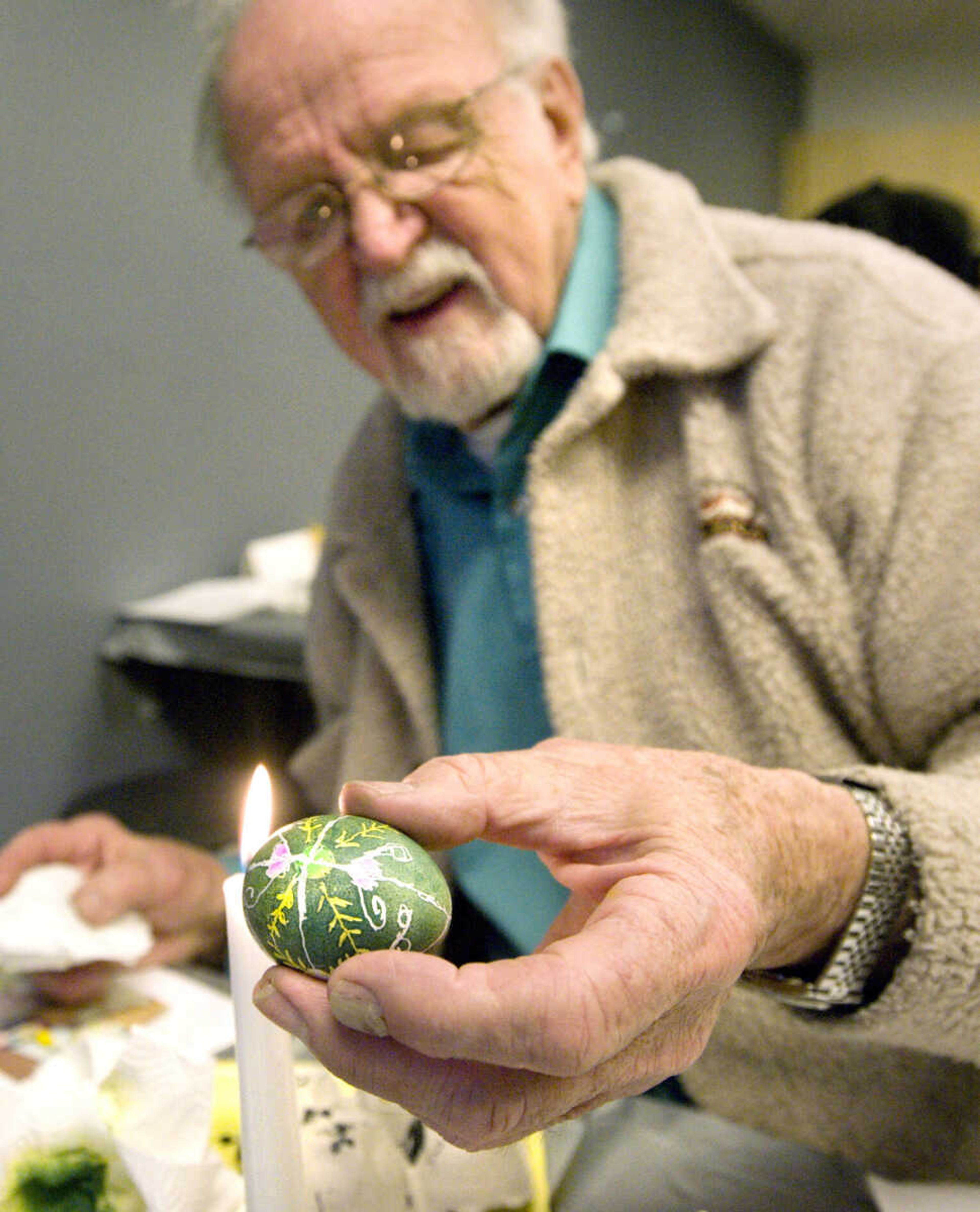 LAURA SIMON ~ lsimon@semissourian.com
Bernard Letassy of Poplar Bluff melts the wax off of his dyed egg Tuesday, March 19, 2013 during the Wonderful World of Pysanky workshop at Southeast Missouri State University's River Campus. In Pysanky, Ukrainian egg art, each color and design is symbolic.  The evergreen on Letassy's egg is a symbol of strength and boldness and the green is a symbol of hope. Instructor Barb Duncan has teaching people of all ages the art of Pysanky for 16 years.