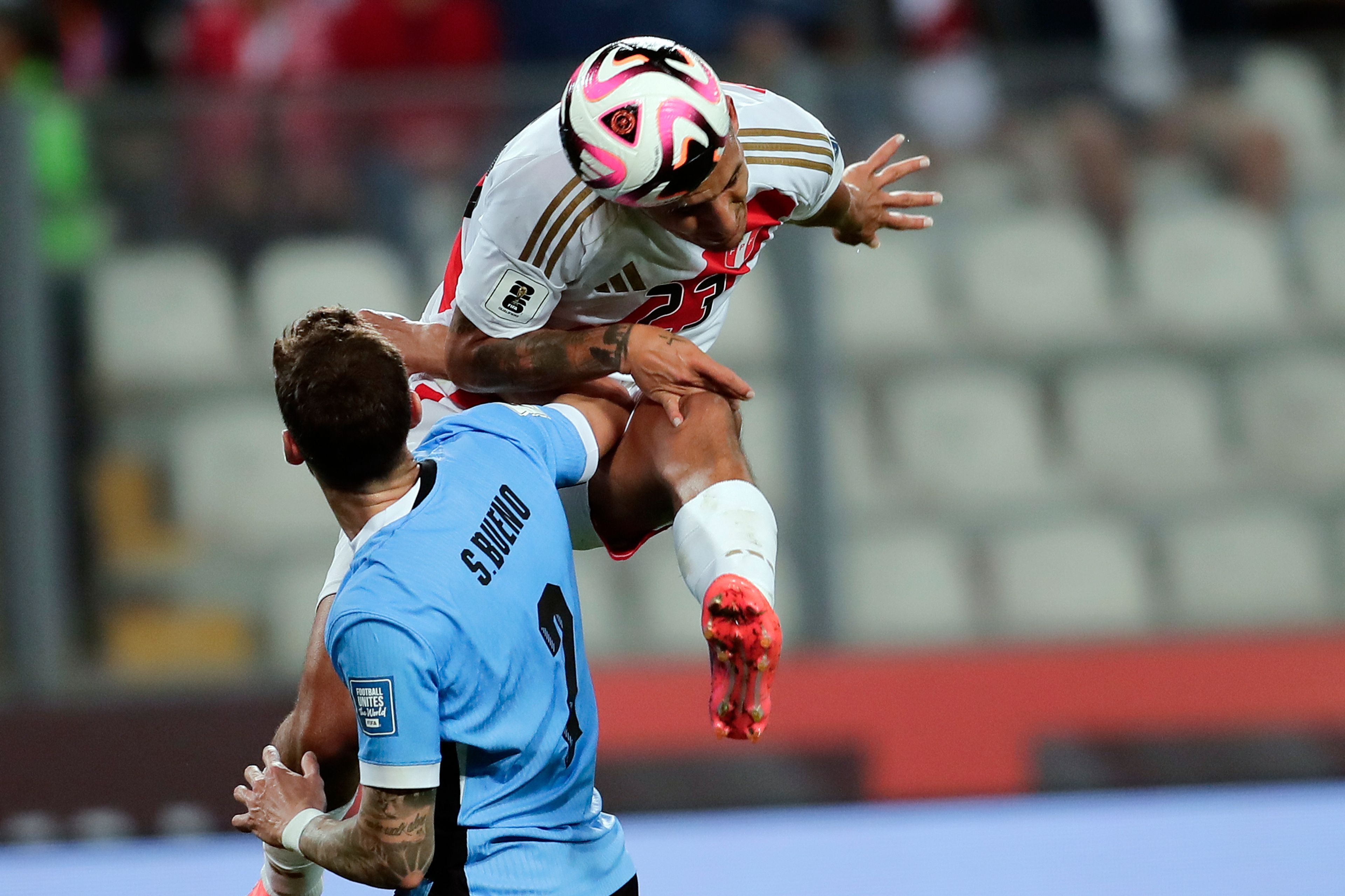 Peru's Alex Valera, top, and Uruguay's Santiago Bueno battle for the ball during a qualifying soccer match for the FIFA World Cup 2026 at National Stadium in Lima, Peru, Friday, Oct. 11, 2024. (AP Photo/Daniel Apuy)