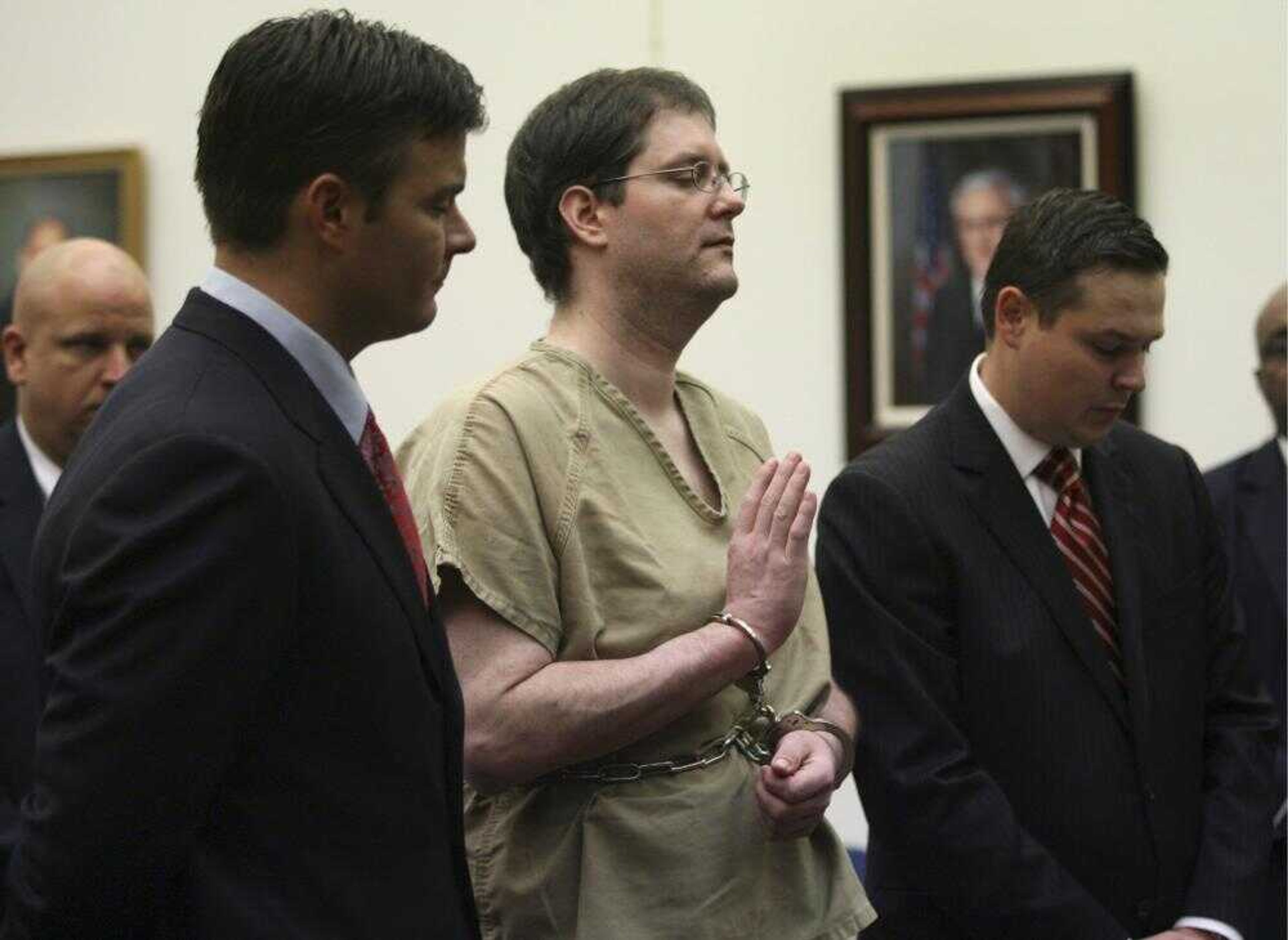 Flanked by defense attorneys Michael Kielty, left, and Ethan Corlija, right, Michael Devlin raised his right hand to be sworn in as he appeared to answer charges against him Tuesday in St. Louis County Circuit Court in Clayton, Mo. (Robert Cohen ~ Pool)