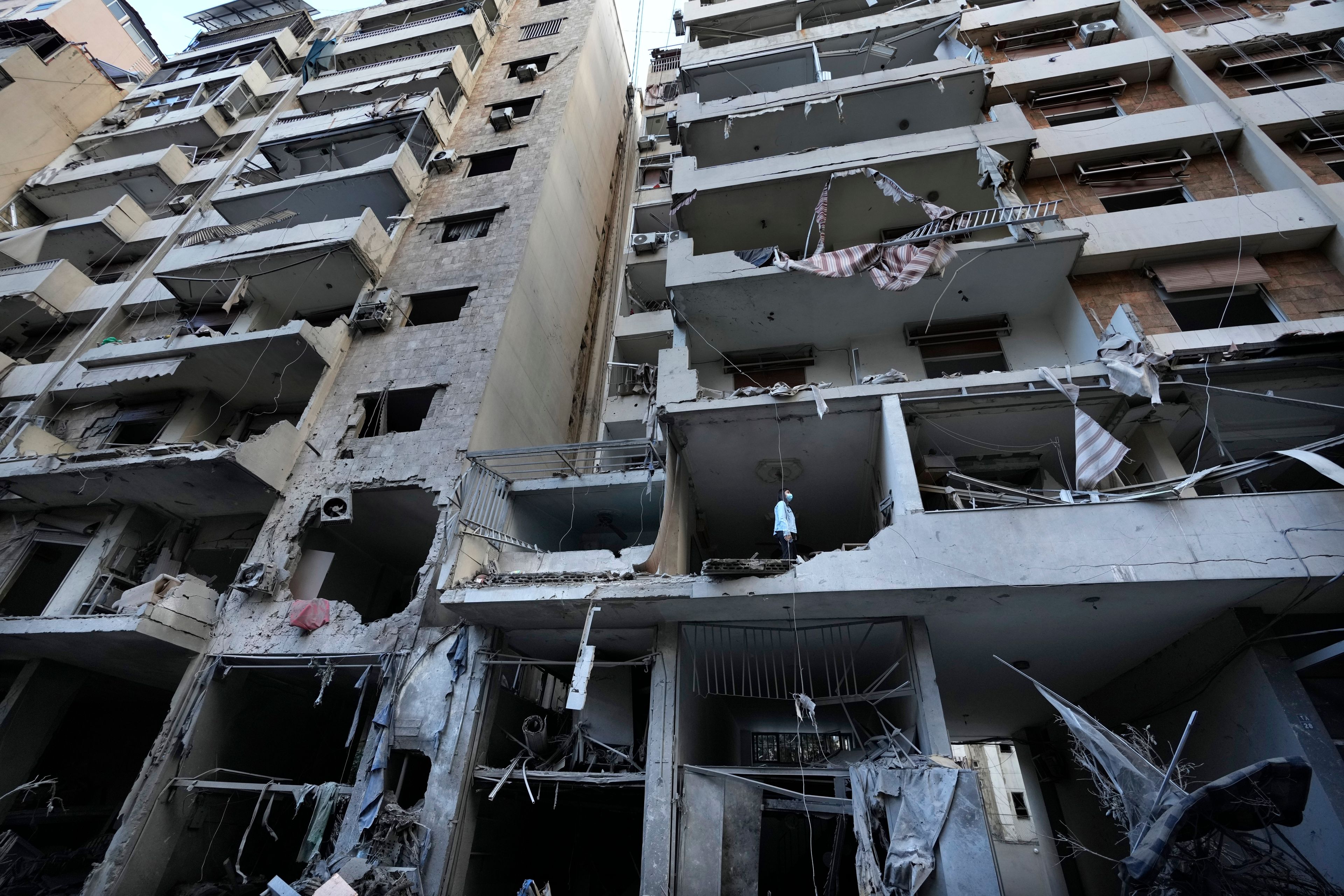 A woman looks through her damaged apartment which was resulted from Sunday's Israeli airstrike in Dahiyeh, in the southern suburb of Beirut, Lebanon, Monday, Nov. 25, 2024. (AP Photo/Hussein Malla)