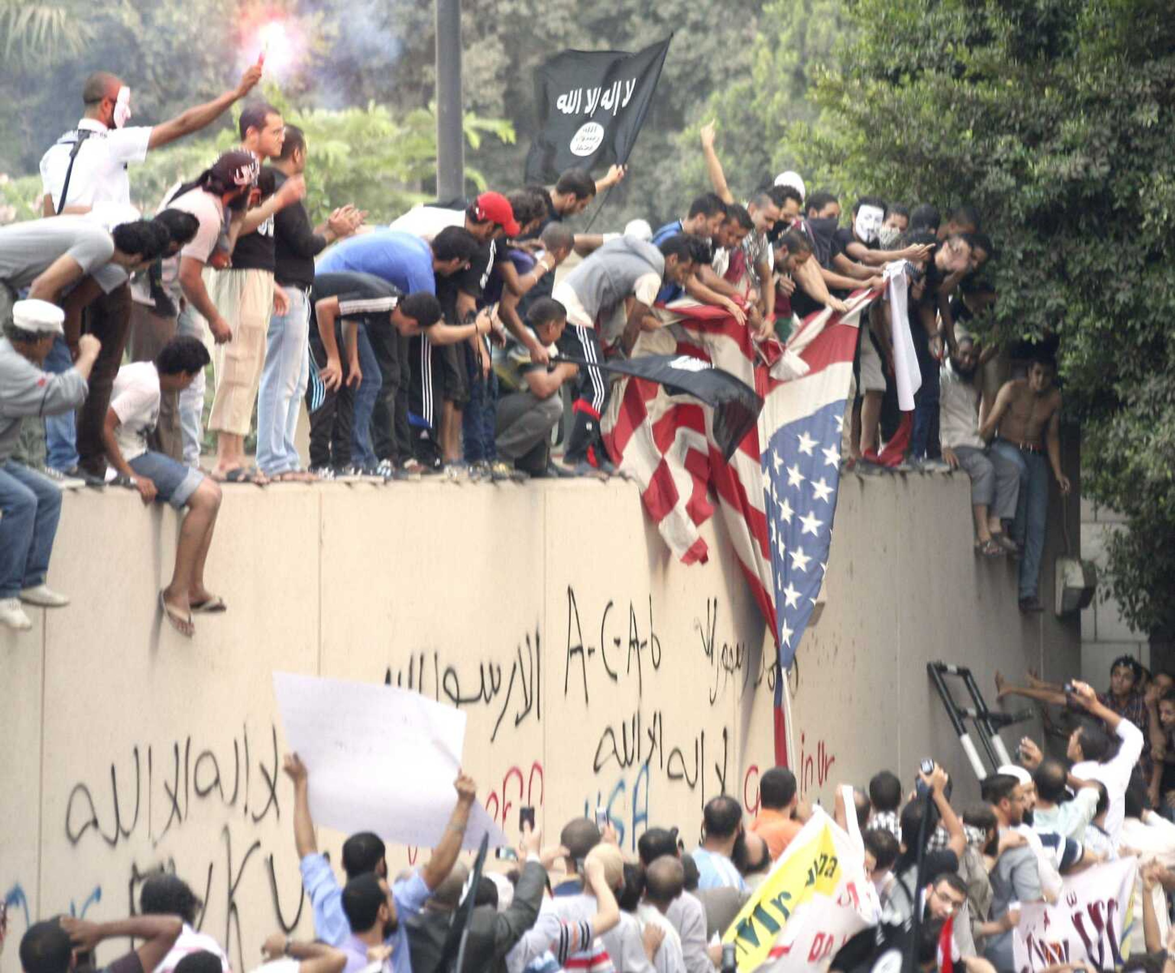 Protesters destroy an American flag pulled down from the U.S. embassy Tuesday in Cairo. (Mohammed Abu Zaid ~ Associated Press)