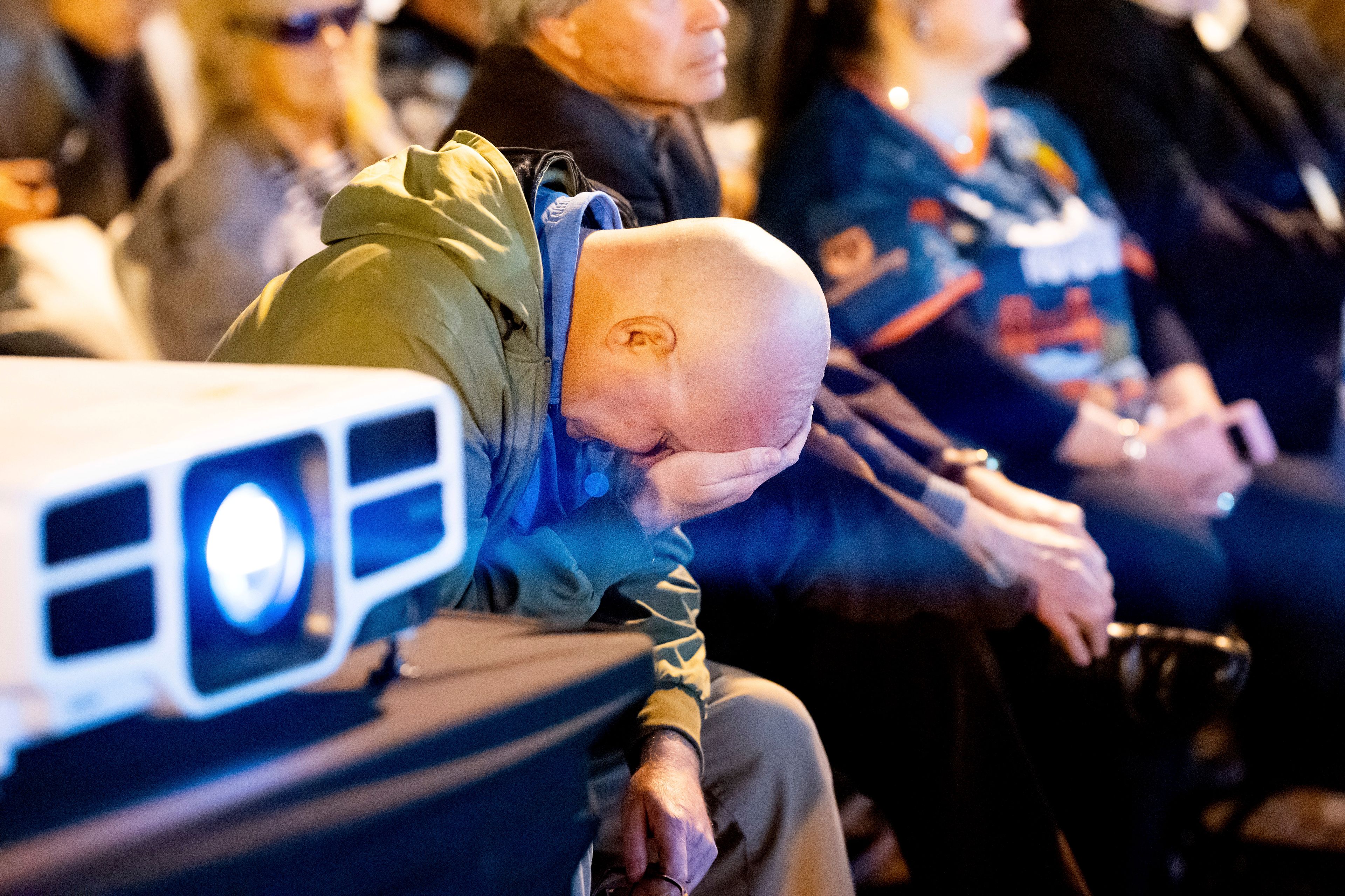 A man, who declined to give his name, reacts while watching election results update on a jumbo screen television in San Francisco on Tuesday, Nov. 5, 2024. (AP Photo/Noah Berger)