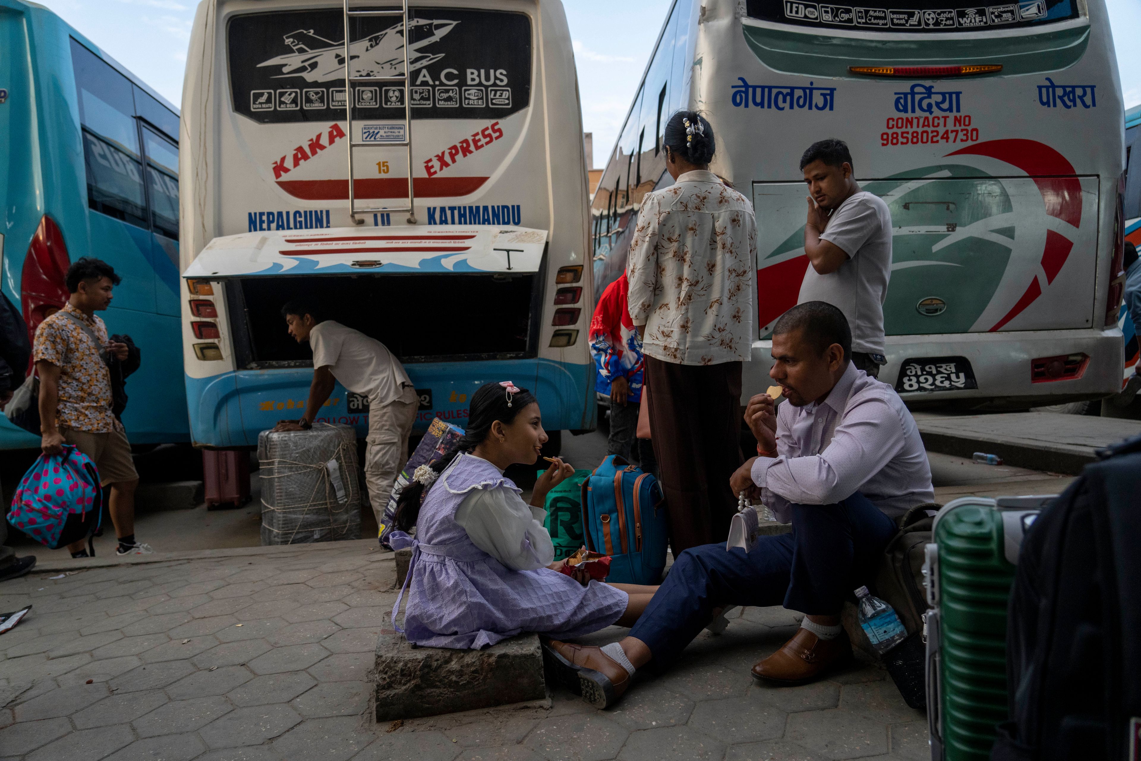 People wait for their buses to travel to their villages to celebrate the Dashain festival at a bus station in Kathmandu, Nepal, Thursday, Oct. 10, 2024. Dashain, the most important religious festival of Nepal's Hindus, commemorates the victory of the Gods over demons. (AP Photo/Niranjan Shrestha)