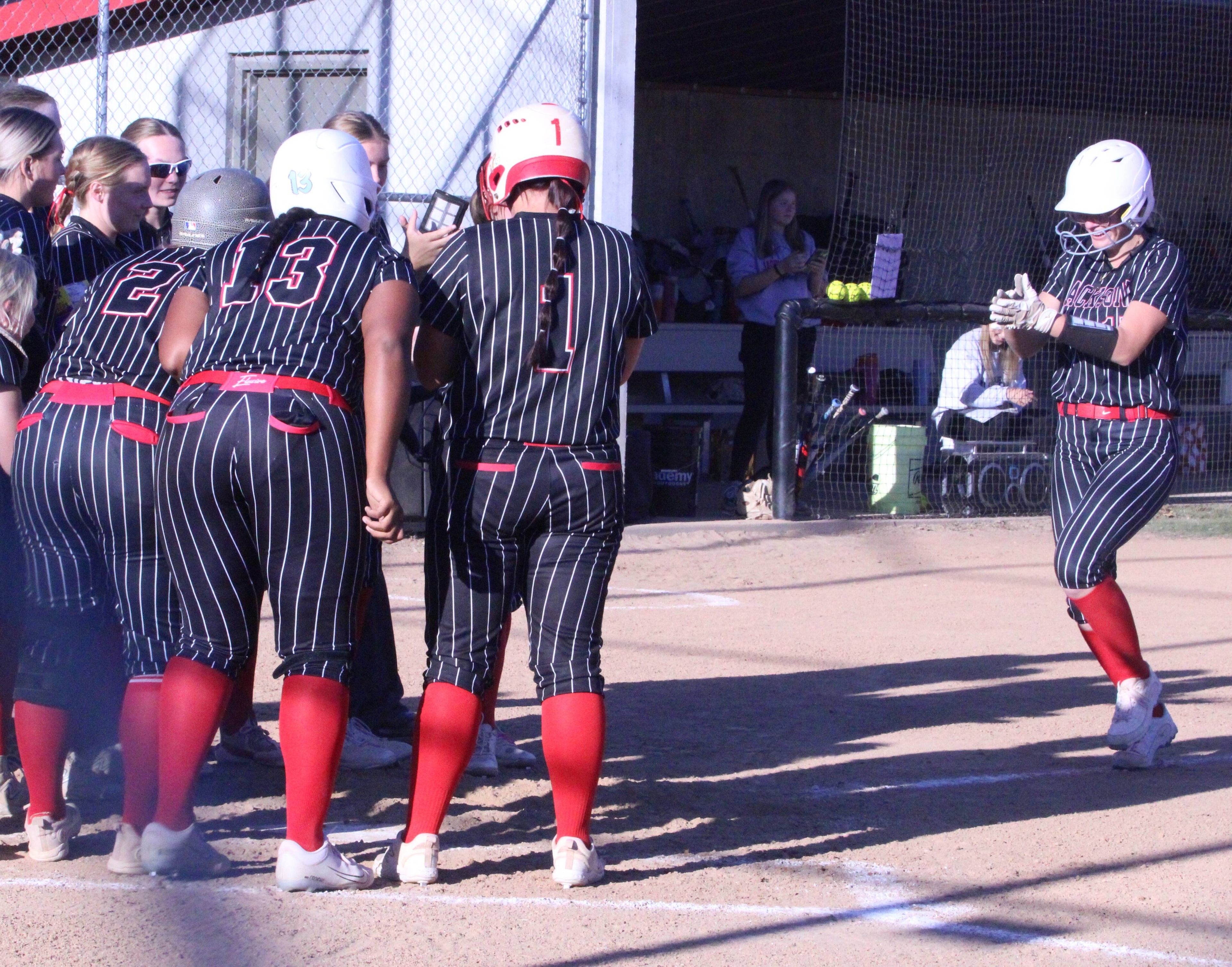 Sydney Miller meets her teammates at home after hitting a grand slam in the Indians' district quarterfinal.