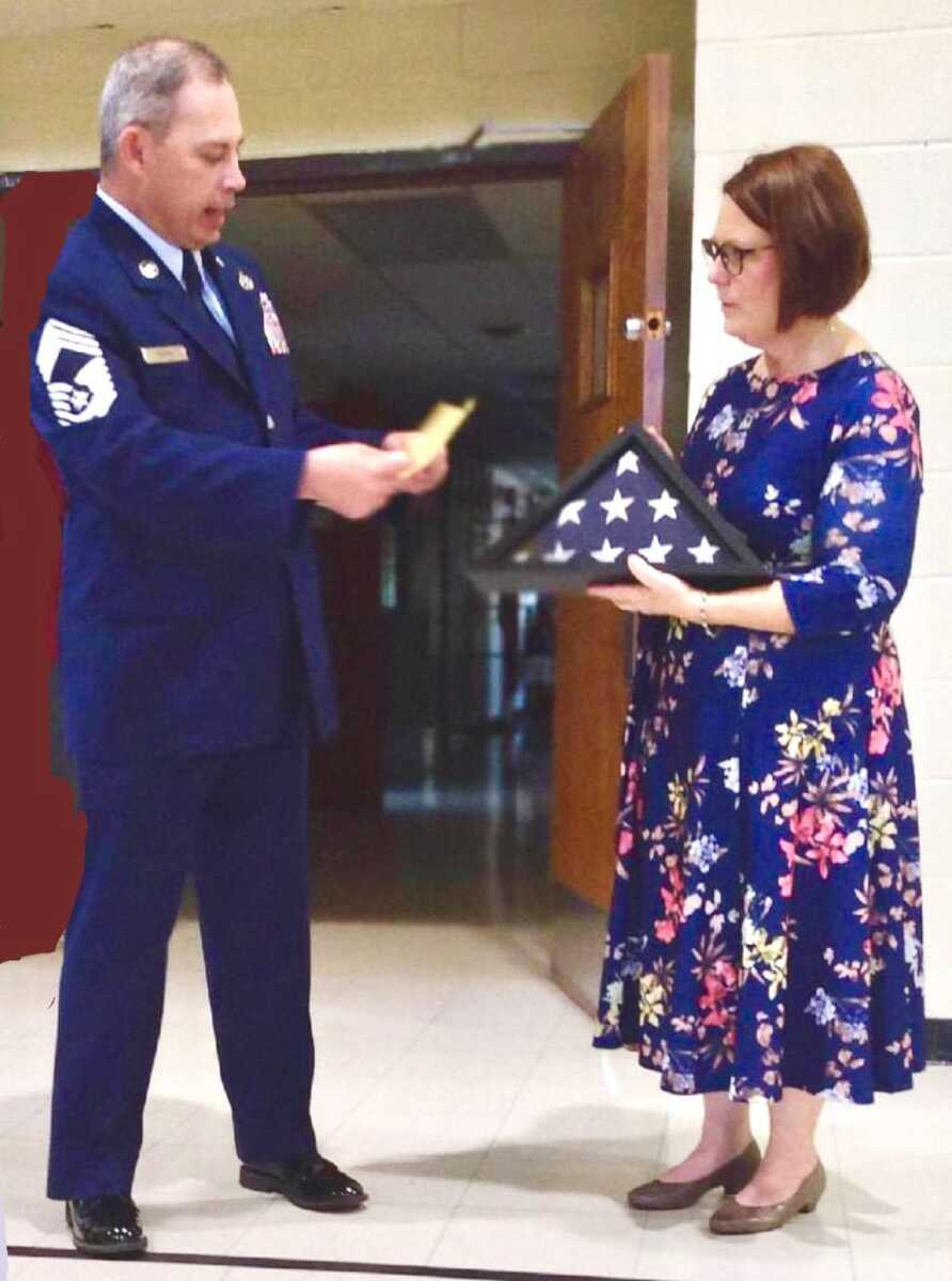 Betty Spalding, principal of St. Joseph Catholic School in Scott City, receives a U.S. flag from former St. Joseph student Donald R. Sturm Jr. of the U.S. Air Force. The flag was flown in combat over Syria and Iran on board a B-1B bomber in support of operation Inherent Resolve in honor of St. Joseph Churchon behalf of Sturm.