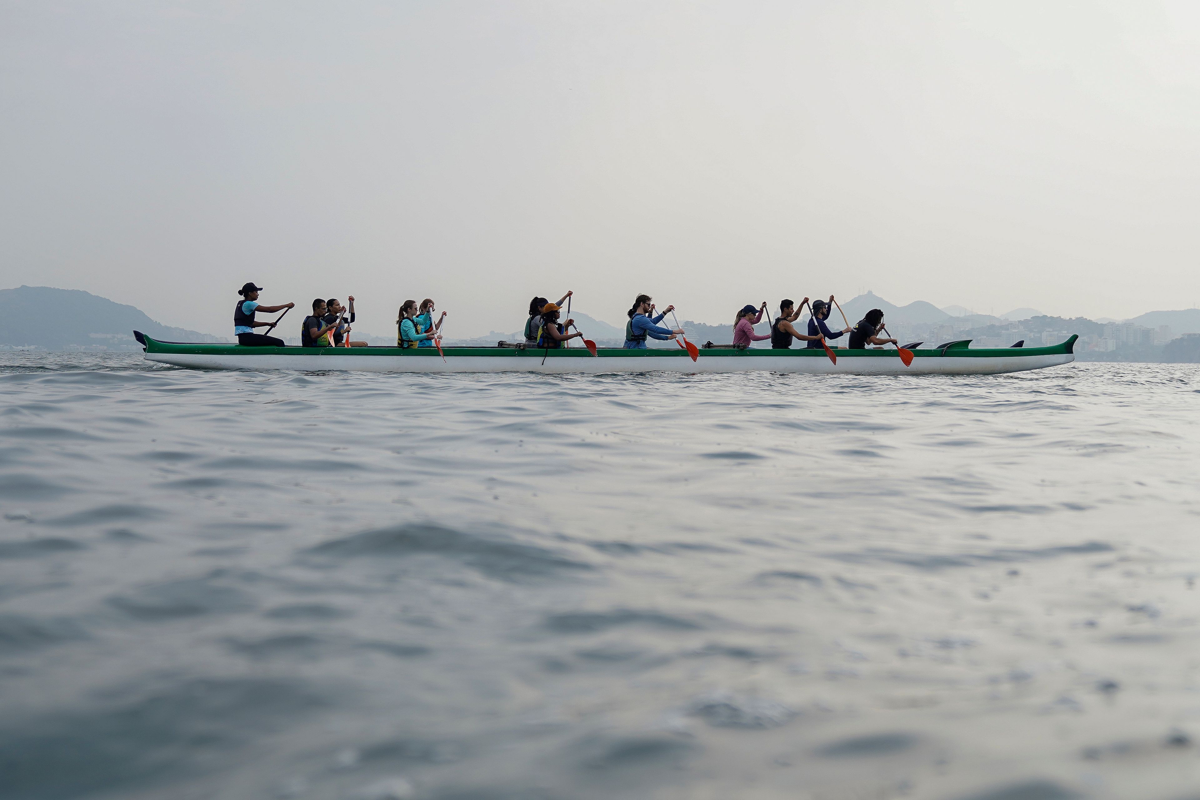 Volunteers paddle canoe as they collect trash in Guanabara Bay as part of World Cleanup Day activities in Rio de Janeiro, Sept. 21, 2024. (AP Photo/Hannah-Kathryn Valles)