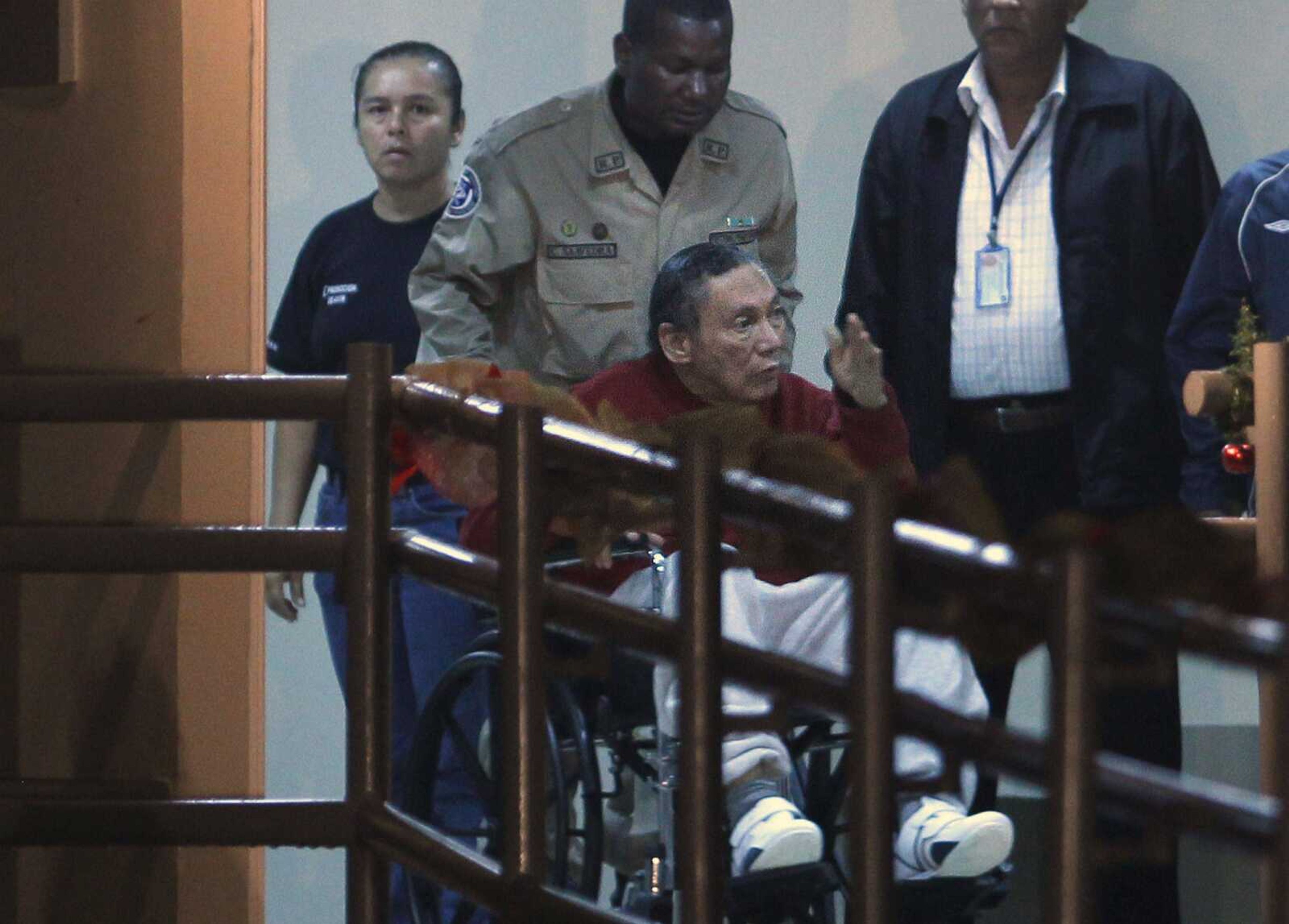 FILE - In this Dec. 11, 2011 file photo, Panama's ex-dictator Manuel Noriega is pushed in a wheelchair by a police officer inside El Renacer prison on the outskirts of Panama City. Noriega, 83, is in critical condition after undergoing two brain surgeries Tuesday, March 7, 2017. Noriega underwent the first procedure Tuesday morning to remove a benign tumor from his brain. But after that surgery, doctors discovered a hemorrhage that forced them to go back in that afternoon, his daughters and lawyer said. (AP Photo/Esteban Felix, File)