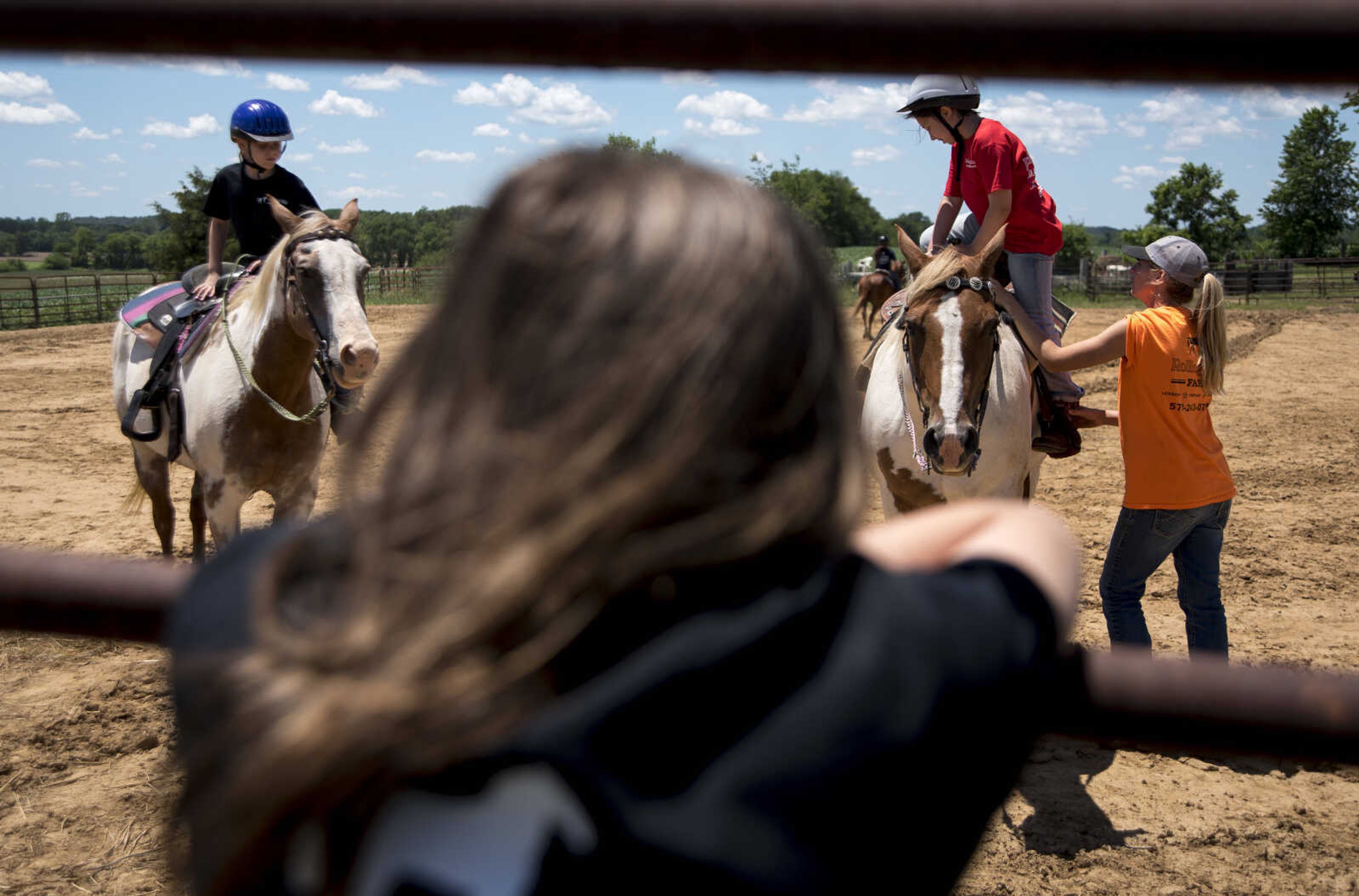 Payton Lynch, 6, and Kyleigh Coch, 11, get off their horses during the Rolling Hills Youth Day Camp Wednesday, June 7, 2017 in Cape Girardeau.