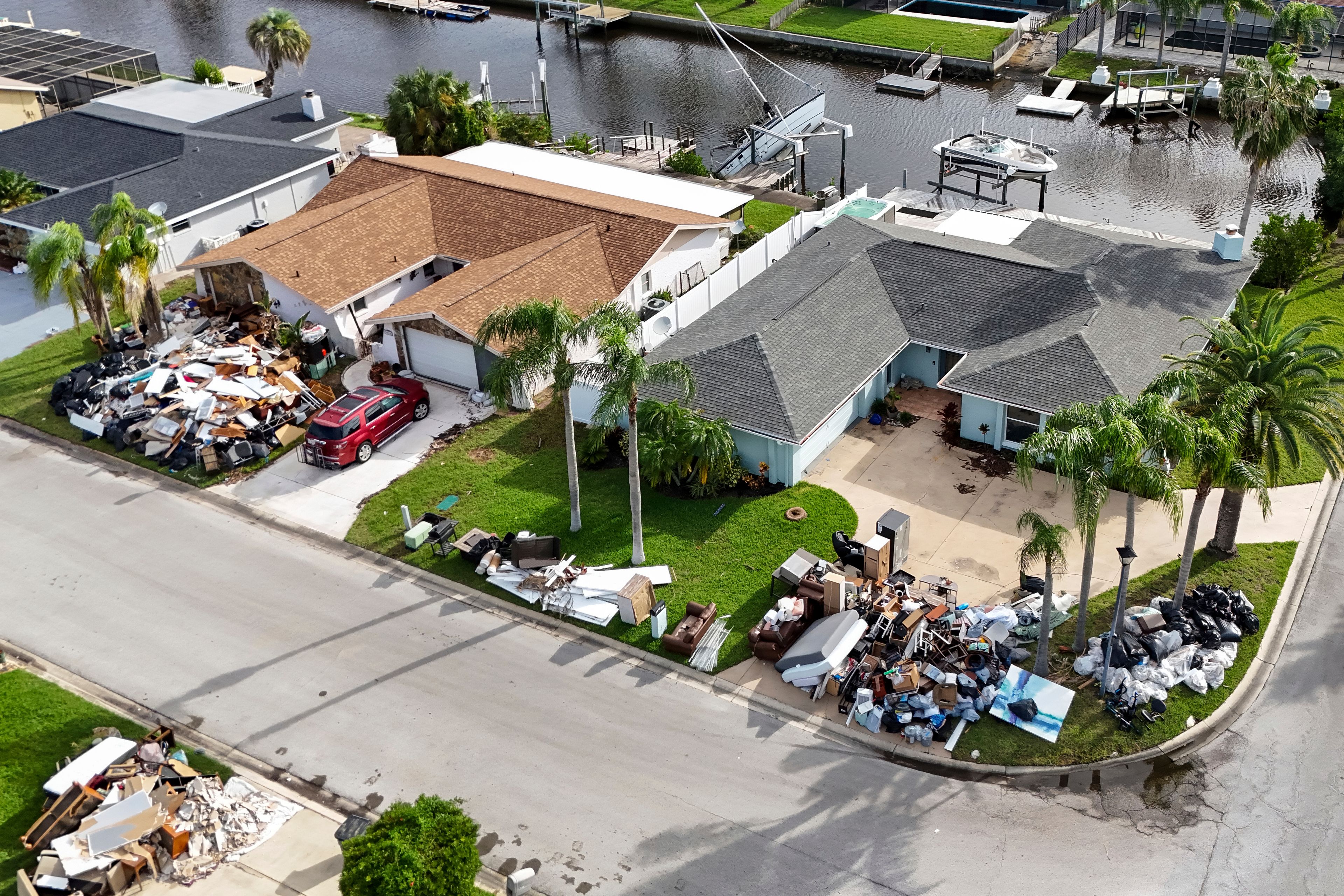 Debris from homes flooded in Hurricane Helene is piled curbside as Hurricane Milton approaches on Tuesday, Oct. 8, 2024, in Port Richey, Fla. (AP Photo/Mike Carlson)