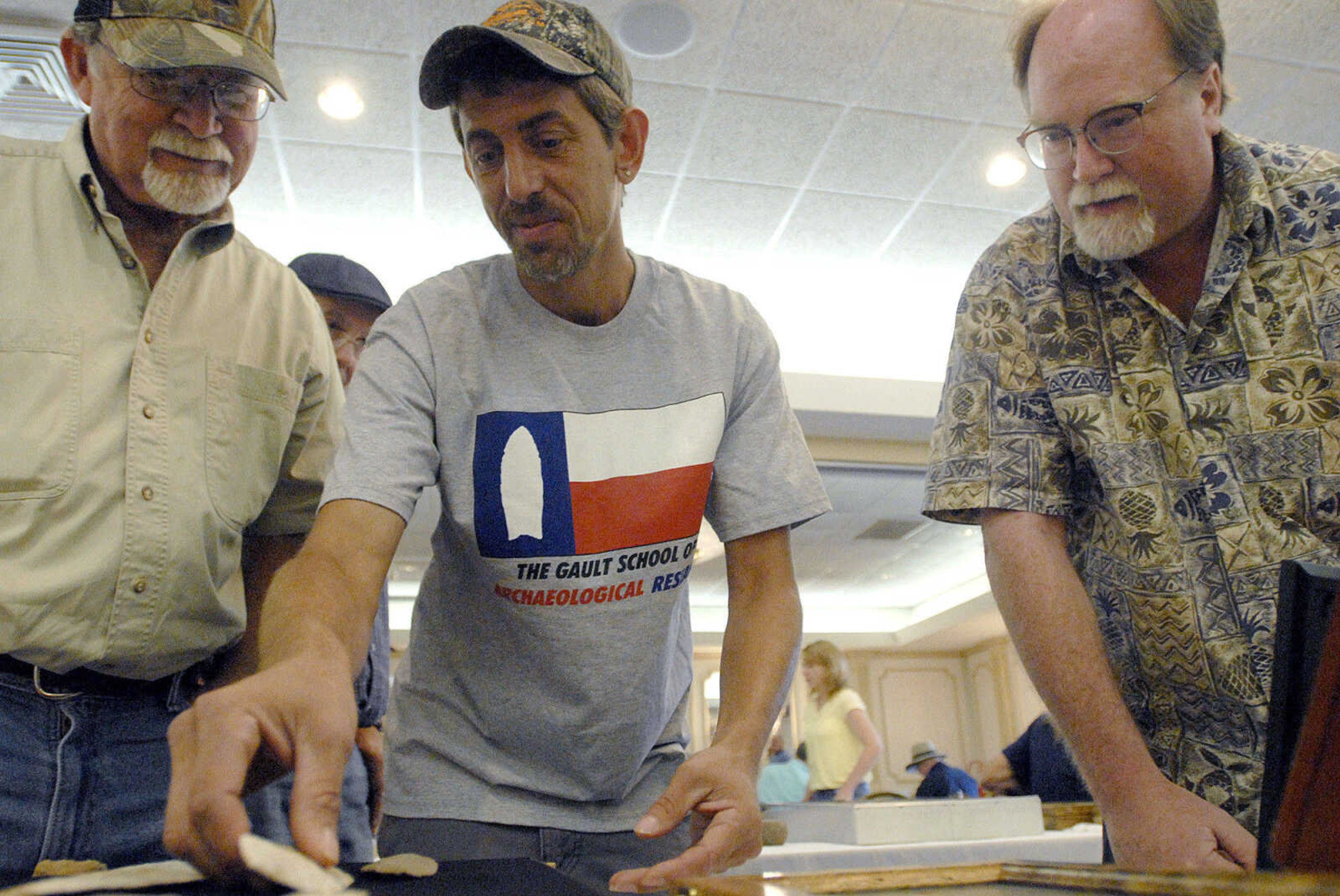 LAURA SIMON ~ lsimon@semissourian.com
Chris Duffy, right, of Carbondale, Ill. looks at Dalton culture blades from Olive Branch, Ill. on display from Jim Marlen, left, and Mack Ashman Sunday, June 26, 2011 during the Bootheel Archeological Society exhibition at Drury Lodge in Cape Girardeau.