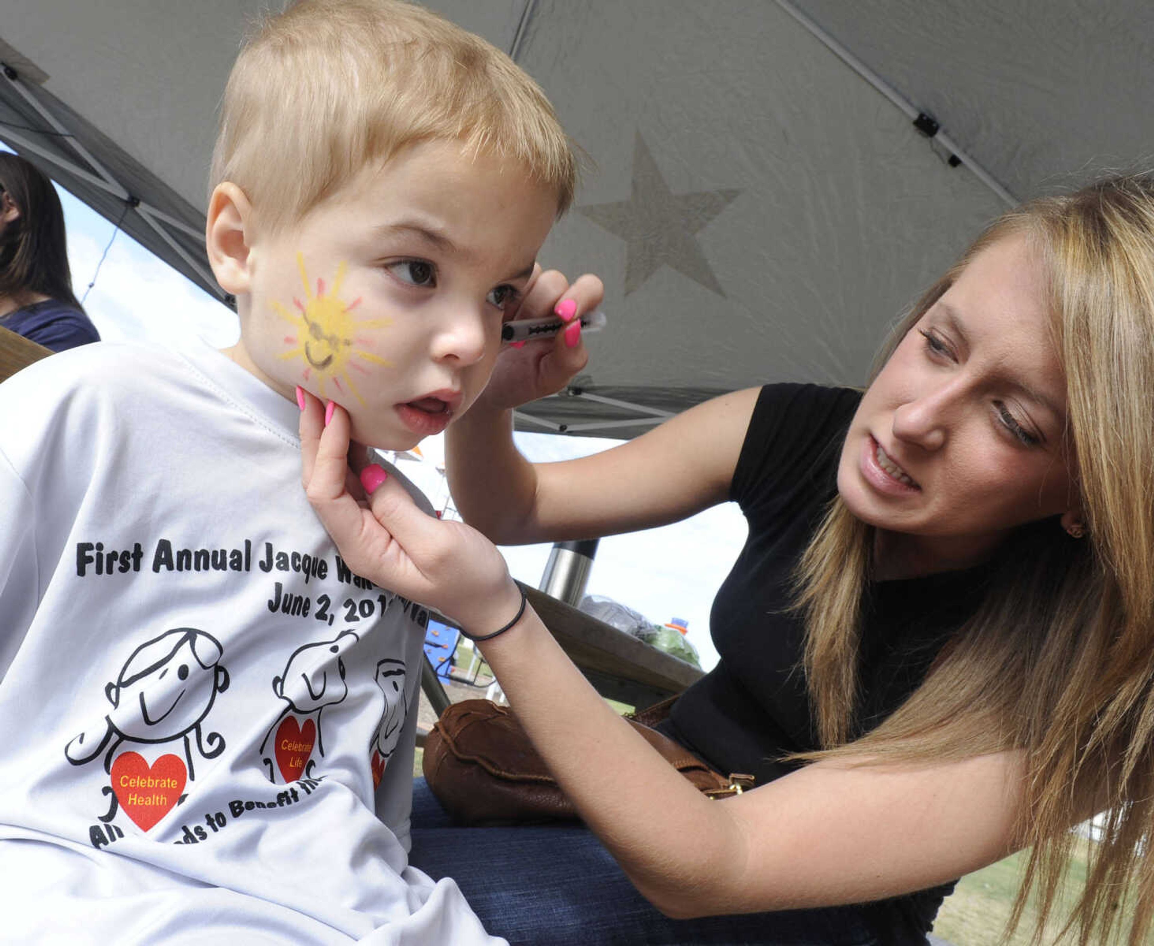 Charlie Sample gets his face painted by Jessica Kettler.