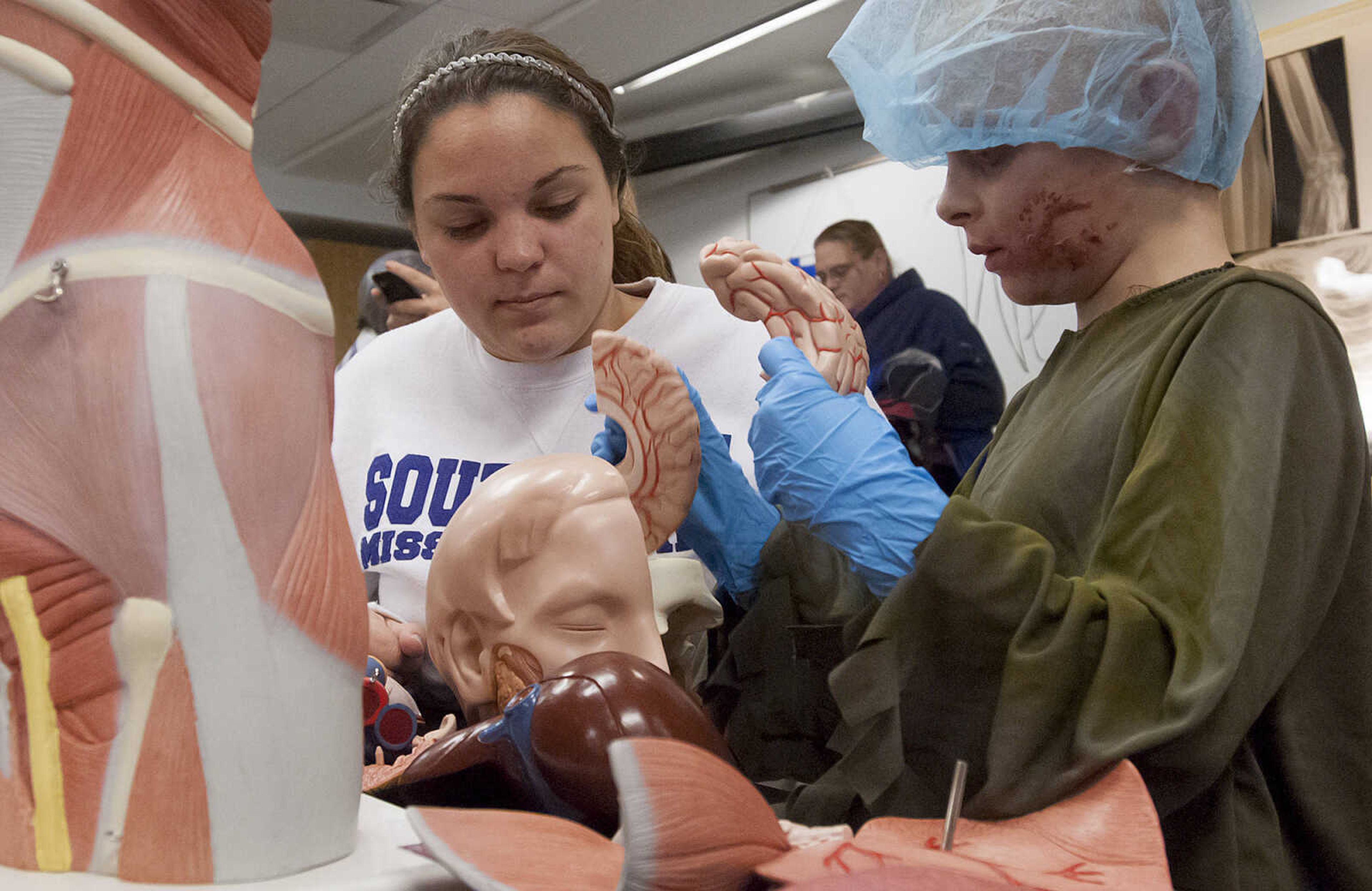 Southeast Missouri State University student Angel Moore, left, halls Koleton Lambert, 7, assemble a body model's parts during the fifth annual Halloween Science Night Sunday, Oct. 20, on the campus of Southeast Missouri State University. The event featured 21 stations, such as the "Scream Room," "Creepy Creatures," or the "Mucus Lab," each with a different Halloween themed science activity. The night is funded by a grant from the Missouri Foundation for Health in partnership with Southeast's College of Science, Technology and Agriculture and Extended and Continuing Education.