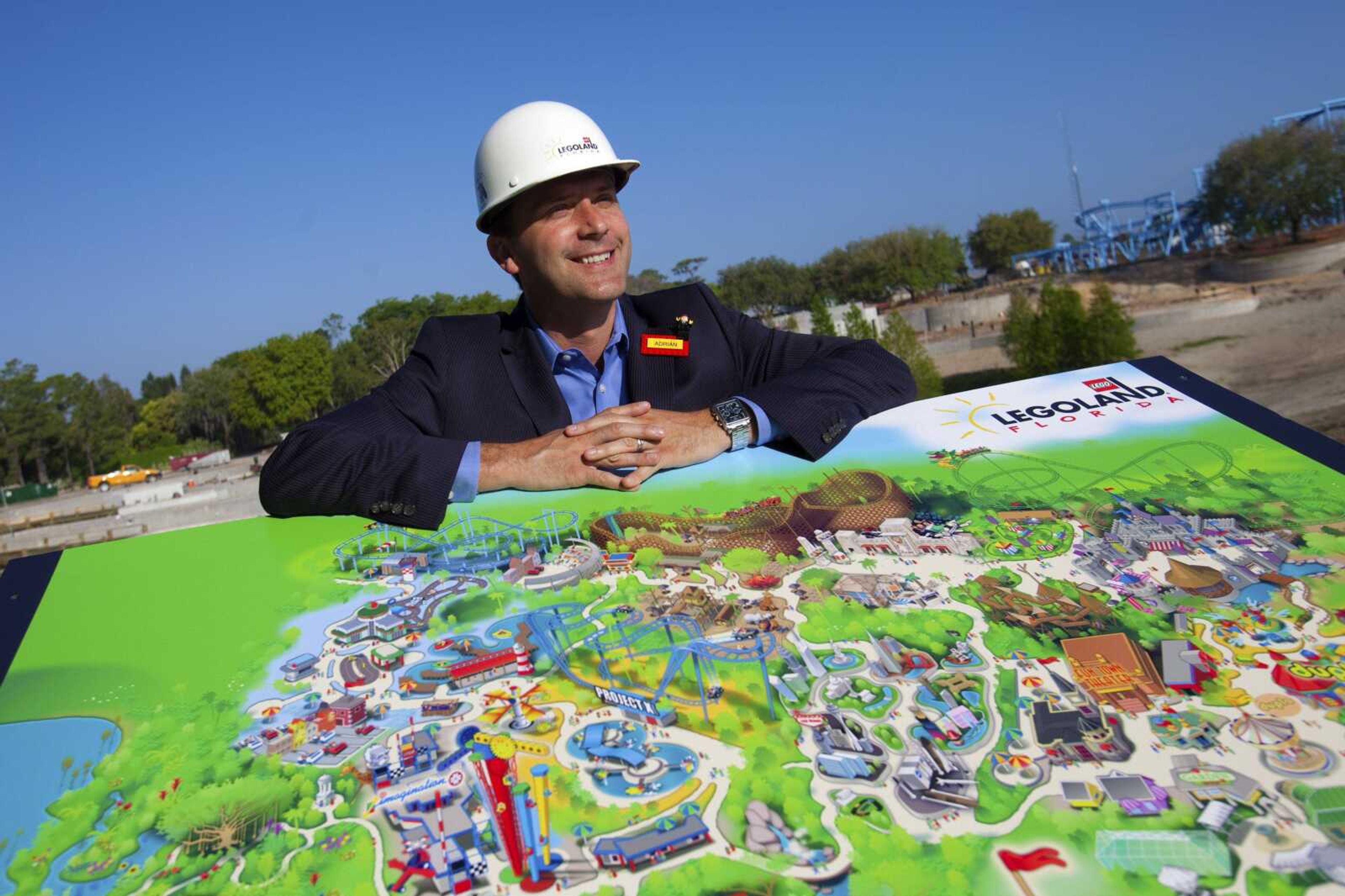 This Wednesday, March 23, 2011 photo courtesy of Chip Litherland for Legoland Florida/Merlin Entertainments Group shows general manager Adrian Jones as he poses for a photograph with a map of Legoland Florida during a preview tour at the park in Winter Haven, Fla. Legoland Florida planners say they are counting on the well-known brand name to draw families to the new theme park when it opens south of Orlando in October. Being built on the old Cypress Gardens site in Winter Haven, the park will be the largest of the five Legolands around the world and a 45-minute drive from Orlando attractions. (AP Photo/Legoland Florida, Merlin Entertainments Group, Chip Litherland) NO SALES; EDITORIAL USE ONLY