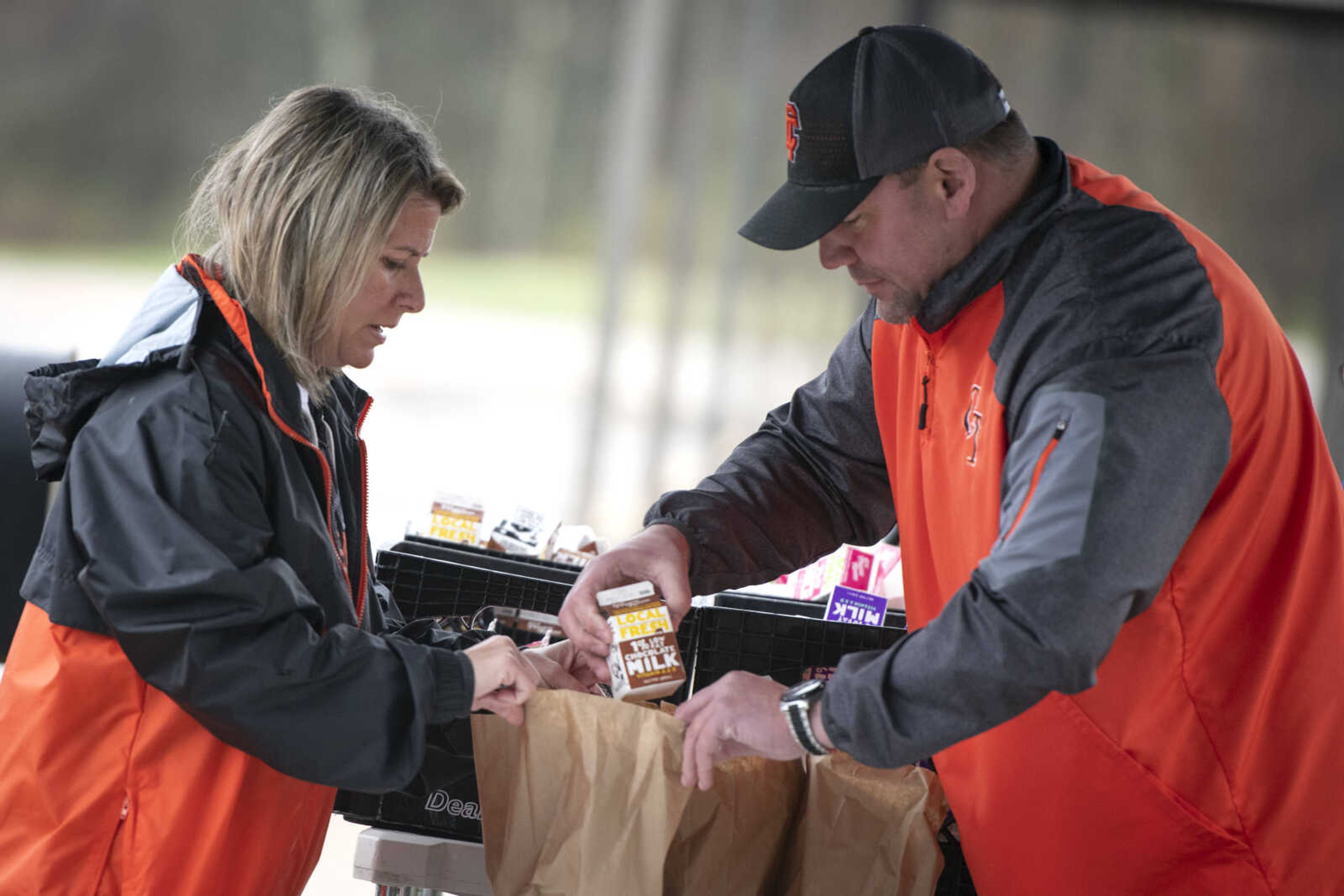 Clippard Elementary principal Amy Emmenderfer, left, and Central Junior High School athletic director Mike Conner get meals ready to give out for those 18 years old and younger Wednesday, March 18, 2020, at Clippard Elementary in Cape Girardeau. Cape Girardeau School District started providing meals to children Wednesday while schools are closed due to concerns over COVID-19. Kristin Tallent, communications director for Cape Girardeau Public Schools, said there are five locations (all of the elementary schools) operating from 10 a.m. to noon Monday through Friday.