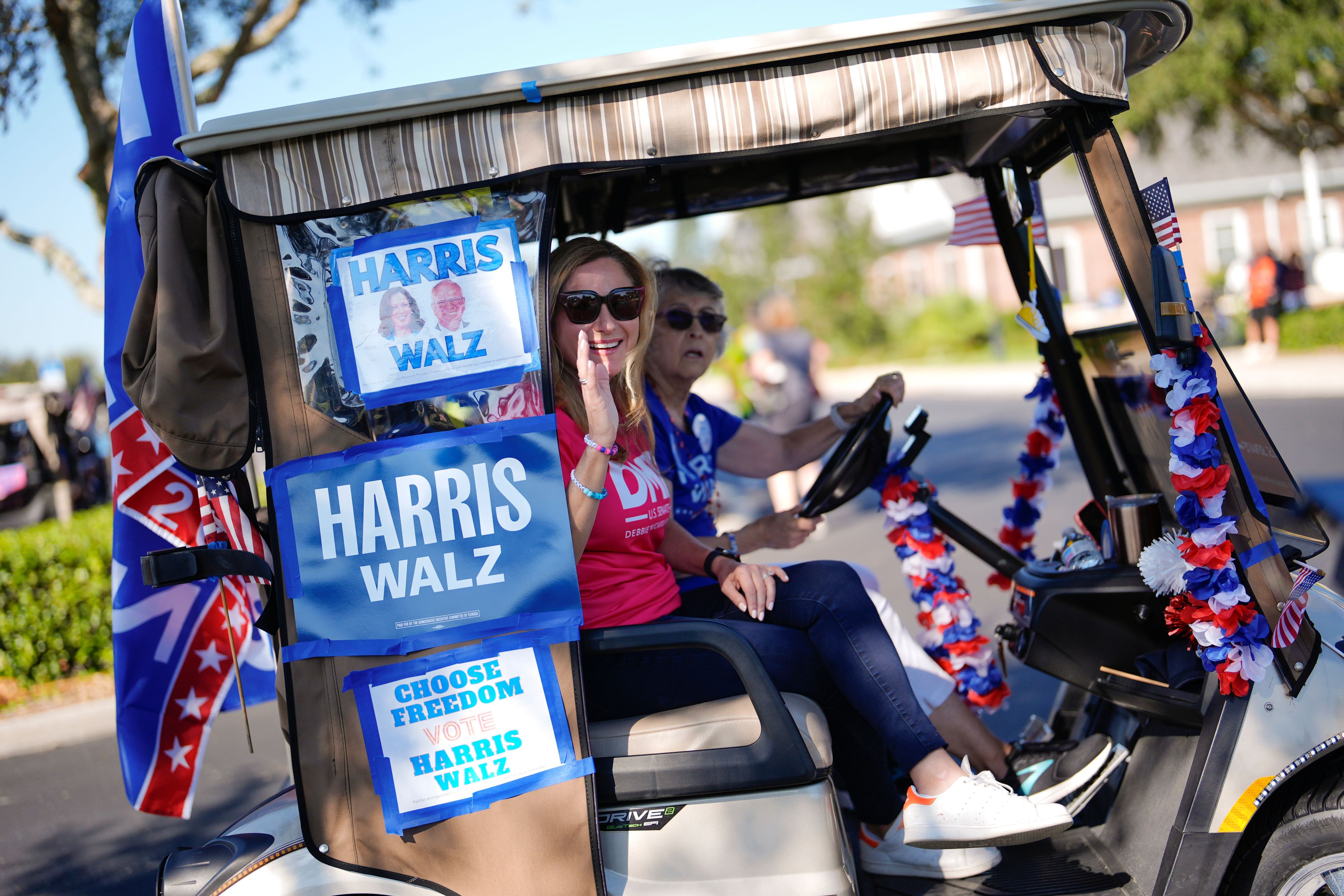 Former Rep. Debbie Mucarsel-Powell of Florida, center, now a Democratic candidate for the U.S. Senate, waves from a cart as she joins hundreds of supporters of Democratic presidential nominee Vice President Kamala Harris in a golf cart parade to deliver their completed mail-in ballots, in The Villages, Fla., Monday, Oct. 14, 2024. The Villages, one of the world's largest retirement communities, has long been known as a conservative stronghold, but Democrats energized by Harris' candidacy have quietly become more visible. (AP Photo/Rebecca Blackwell)