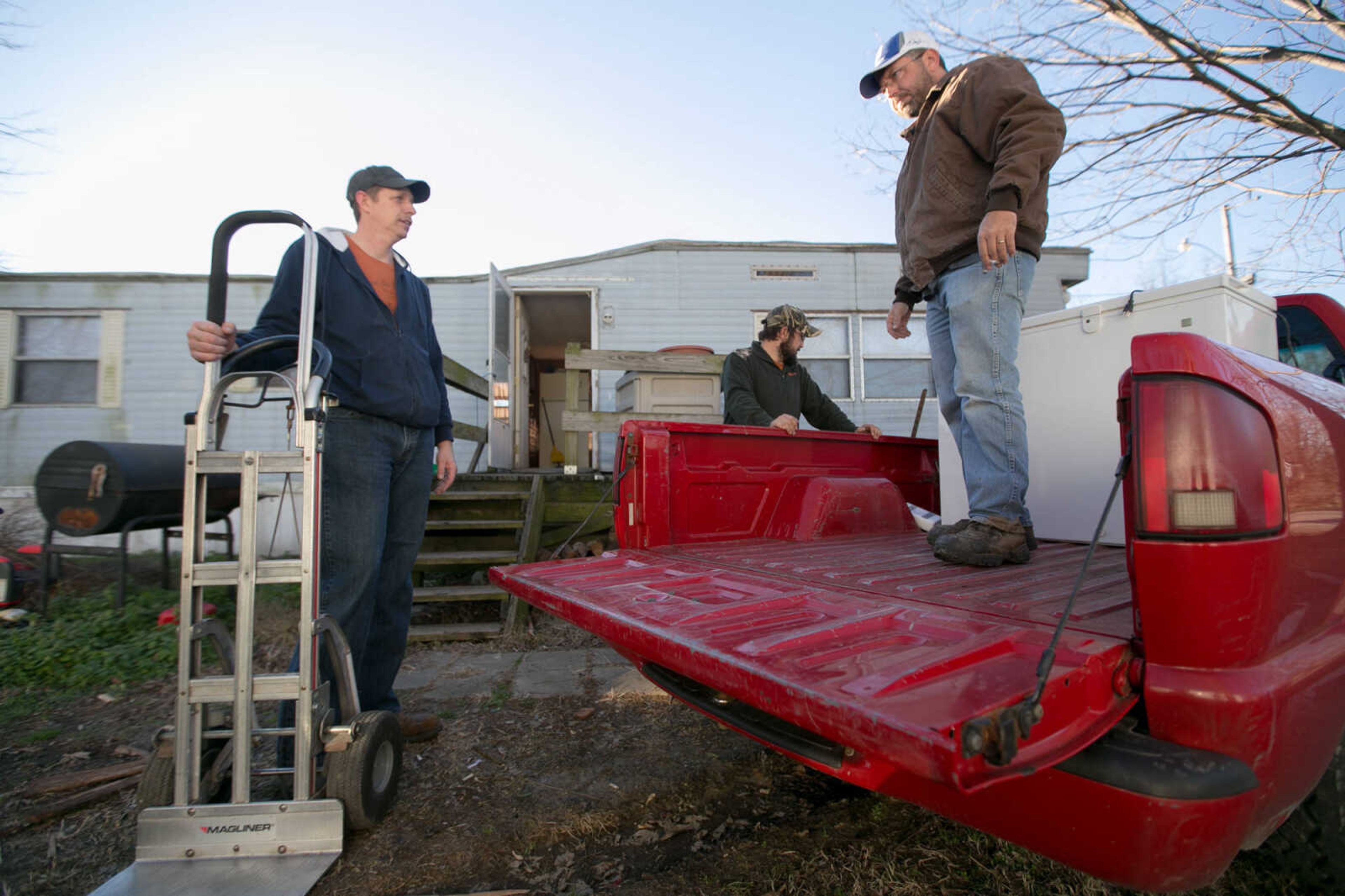 GLENN LANDBERG ~ glandberg@semissourian.com

Dale Schultz, right, rests after loading a freezer into the bed of a truck as he evacuates his home in McClure, Illinois with help from John Schultz and Clint Nale, Friday, Jan. 1, 2016.