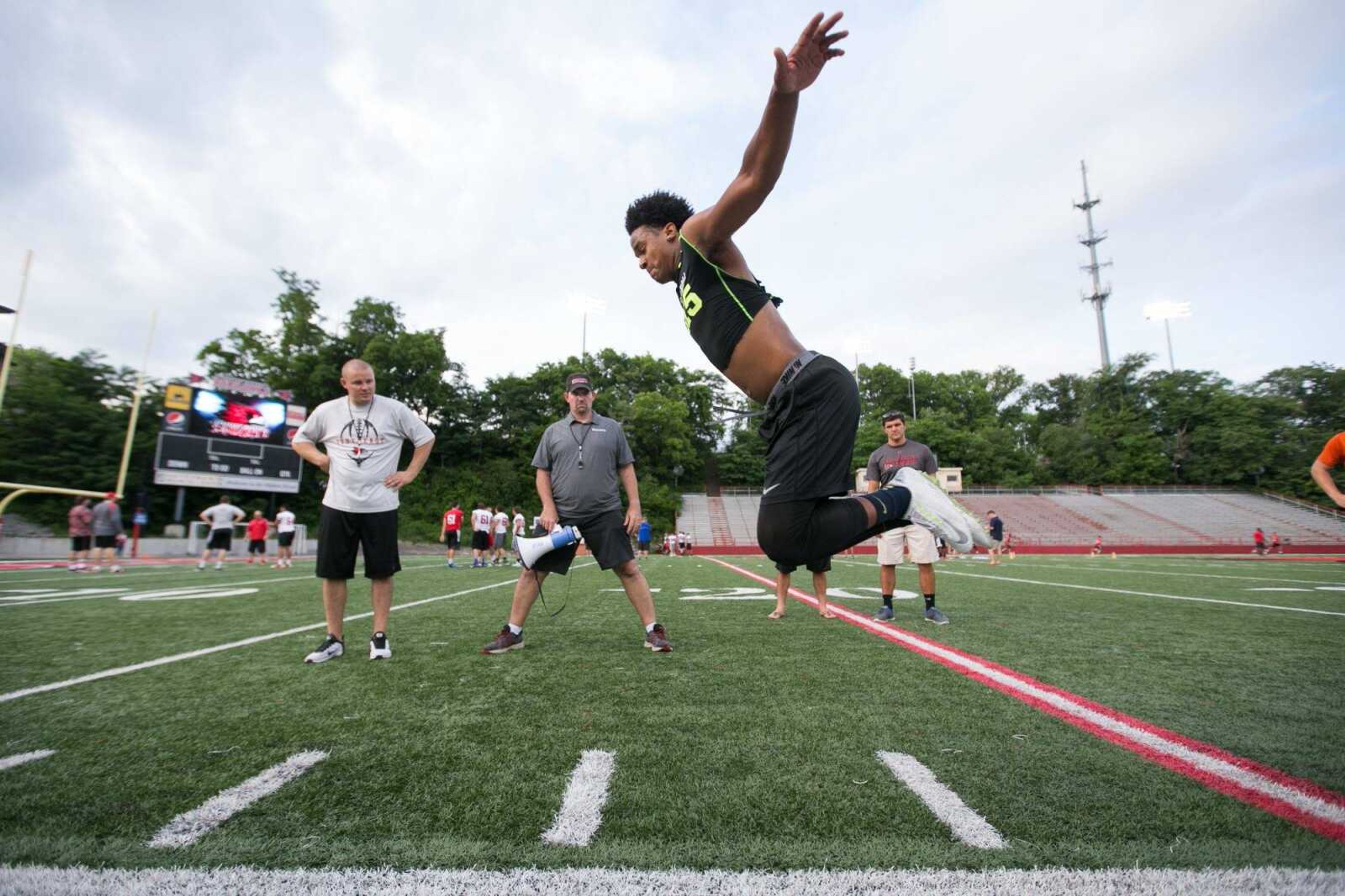 GLENN LANDBERG ~ glandberg@semissourian.com <br>  <br> Chanse Pullen performs a broad jump for Southeast Missouri State University coach <br> Tom Matukewicz and Matt Martin during a football prospect camp at Houck Stadium, Friday, June 5, 2015.