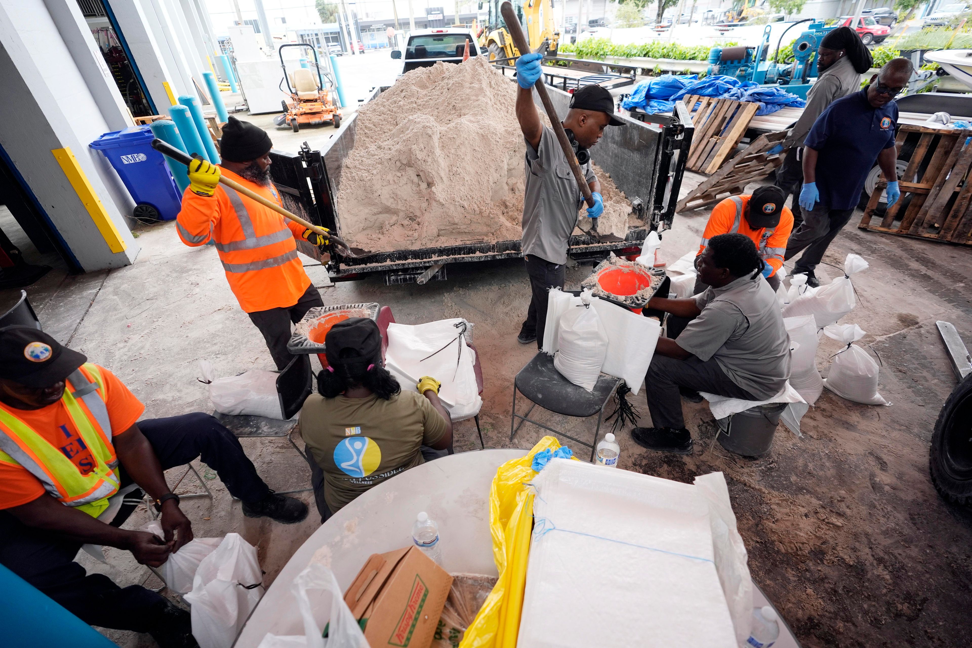 North Miami Beach, Fla., public service workers fill sandbags, to distribute to residents to help prevent flooding, as Hurricane Milton prepares to strike Florida, Tuesday, Oct. 8, 2024, in North Miami Beach. (AP Photo/Wilfredo Lee)