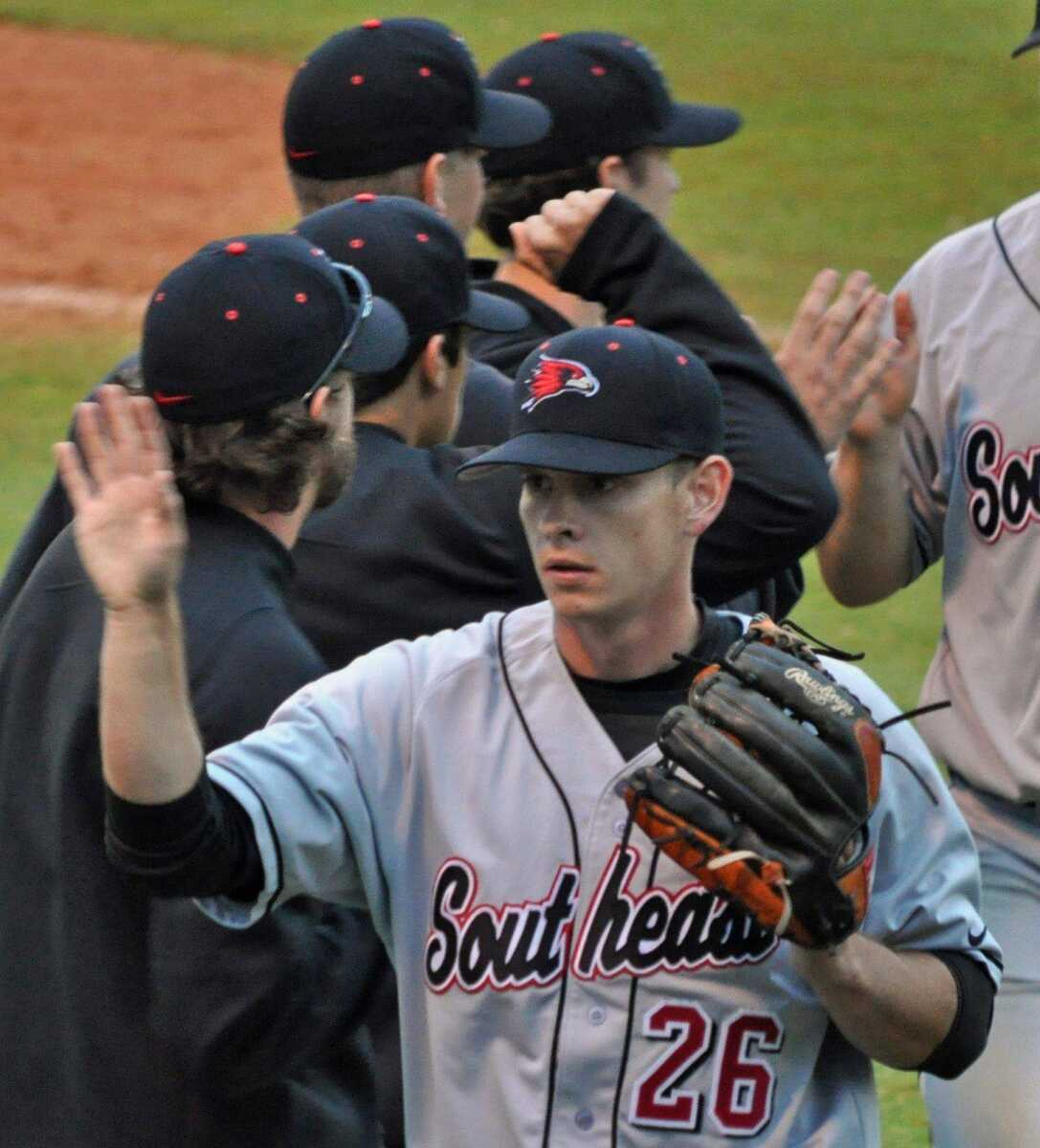 LEFT: Southeast Missouri State outfielder Nick Harris is helped off the field after injuring his knee in Game 2. ABOVE: Southeast Missouri State second baseman Tim Rupp turns a double play during the first game.