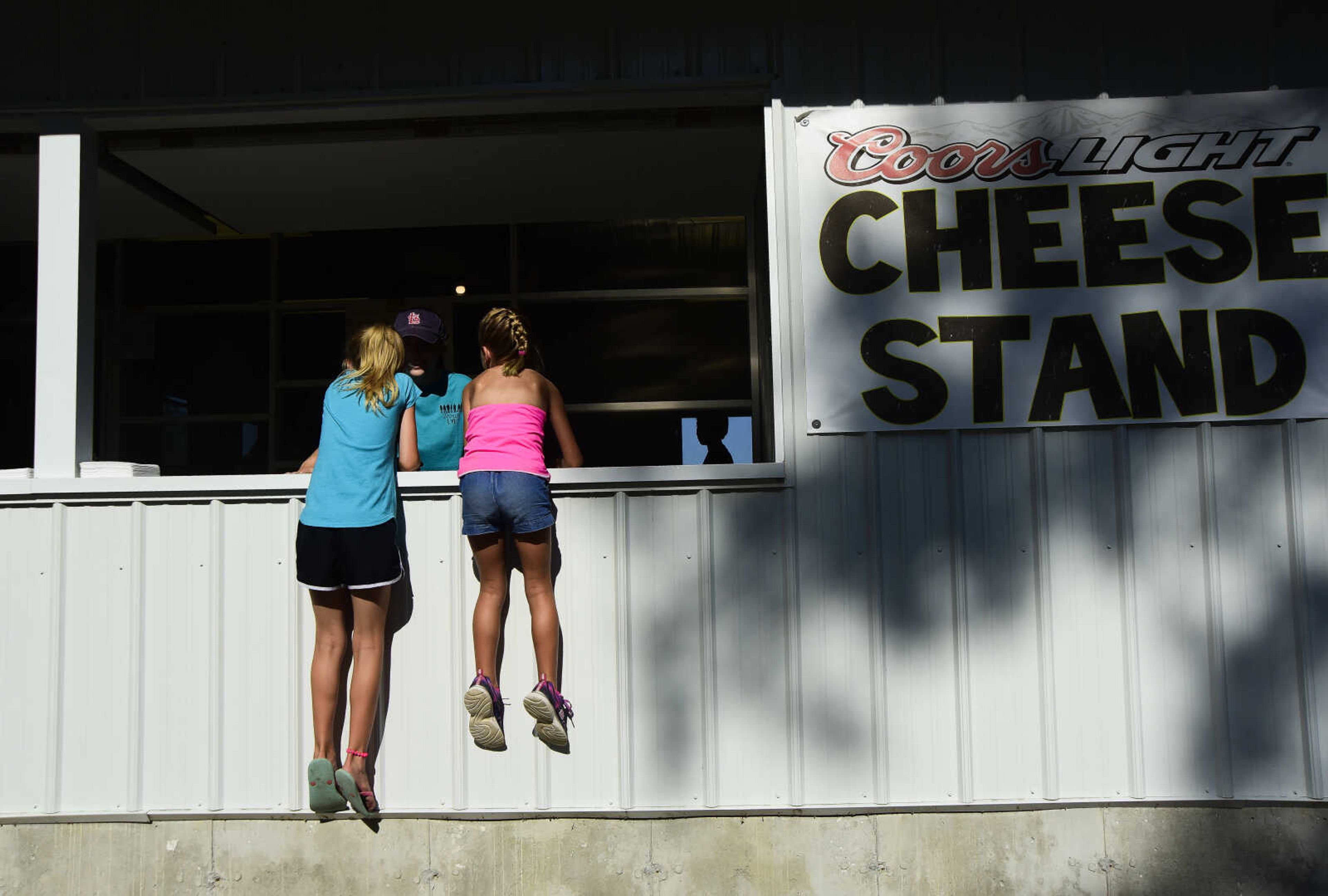 Lydia Schlimpert, 9, left, and Madelyn Head, 9, right, wait for their ice-cream for the Trinity Church Picnic Sunday, July 16, 2017 at the Altenburg Fairgrounds.