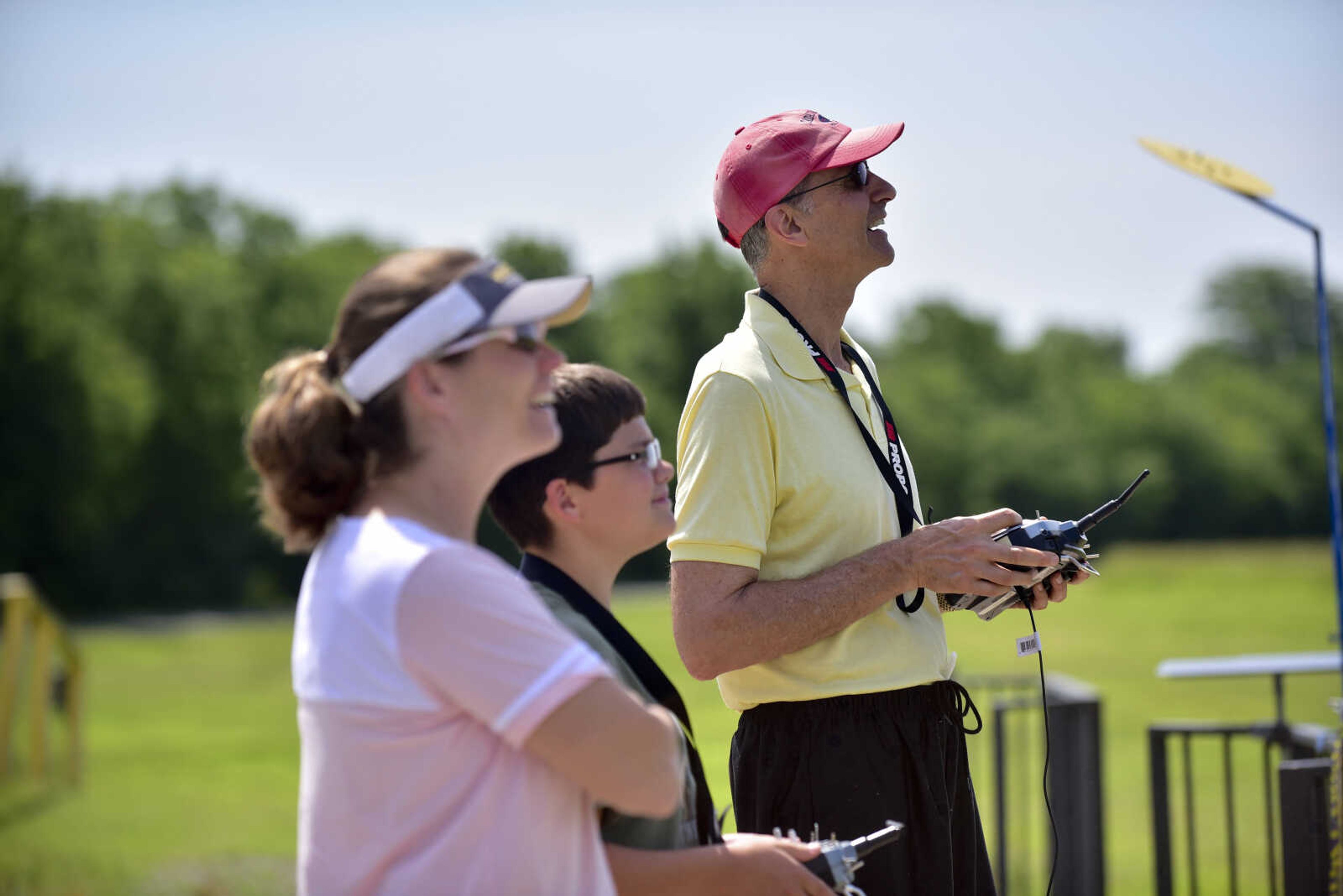 John Coffman, right, shows Kristen Lewis and Gabe Lewis how to fly a model airplane for the Cape Fly Hi radio controlled aircraft demonstration Saturday, June 3, 2017 at Galaxy Park in Cape Girardeau.