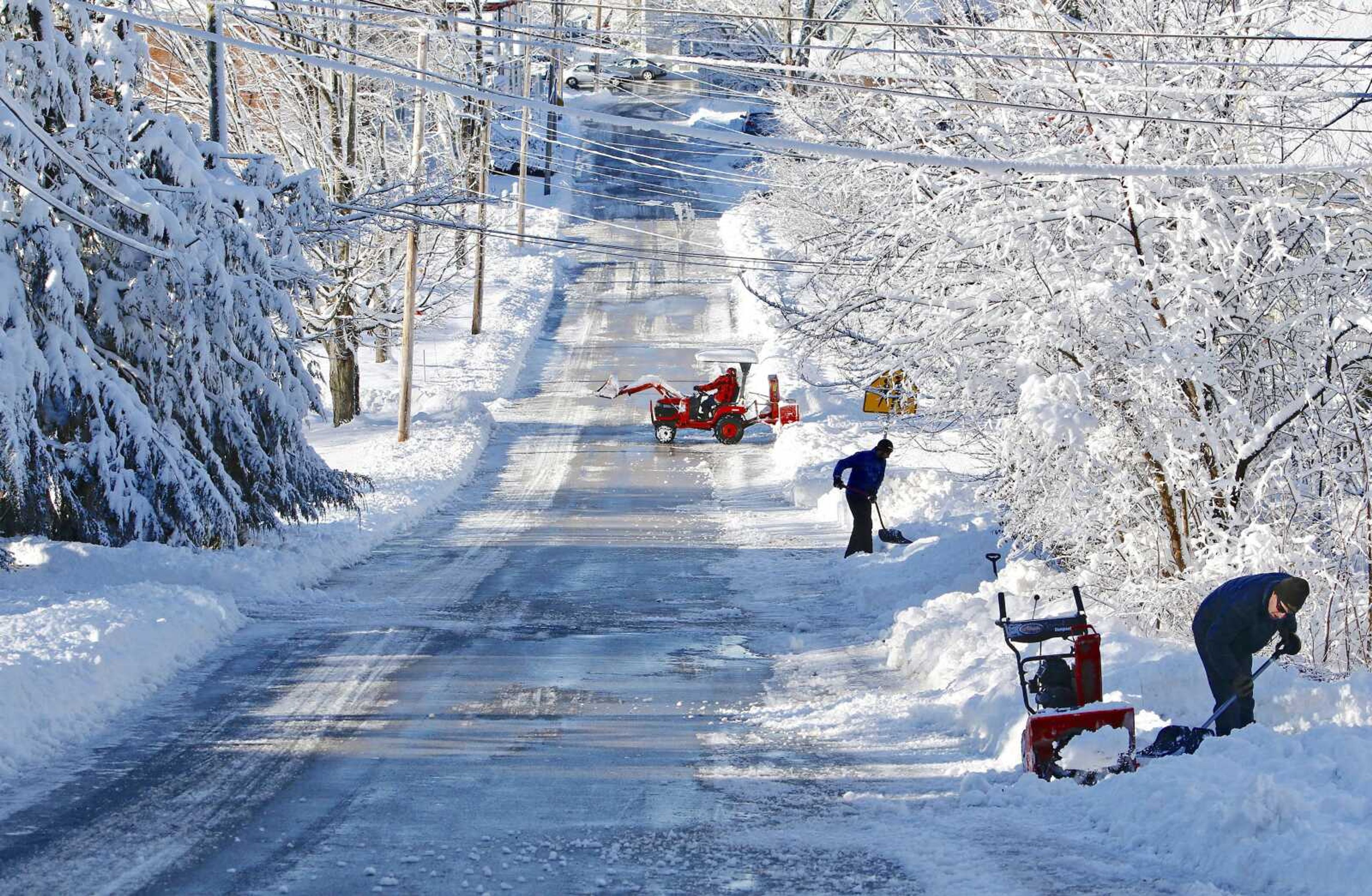 Residents along Paul Street clear snow from their driveways Friday in South Berwick, Maine, after 5 to 6 inches of wet, heavy snow fell overnight.