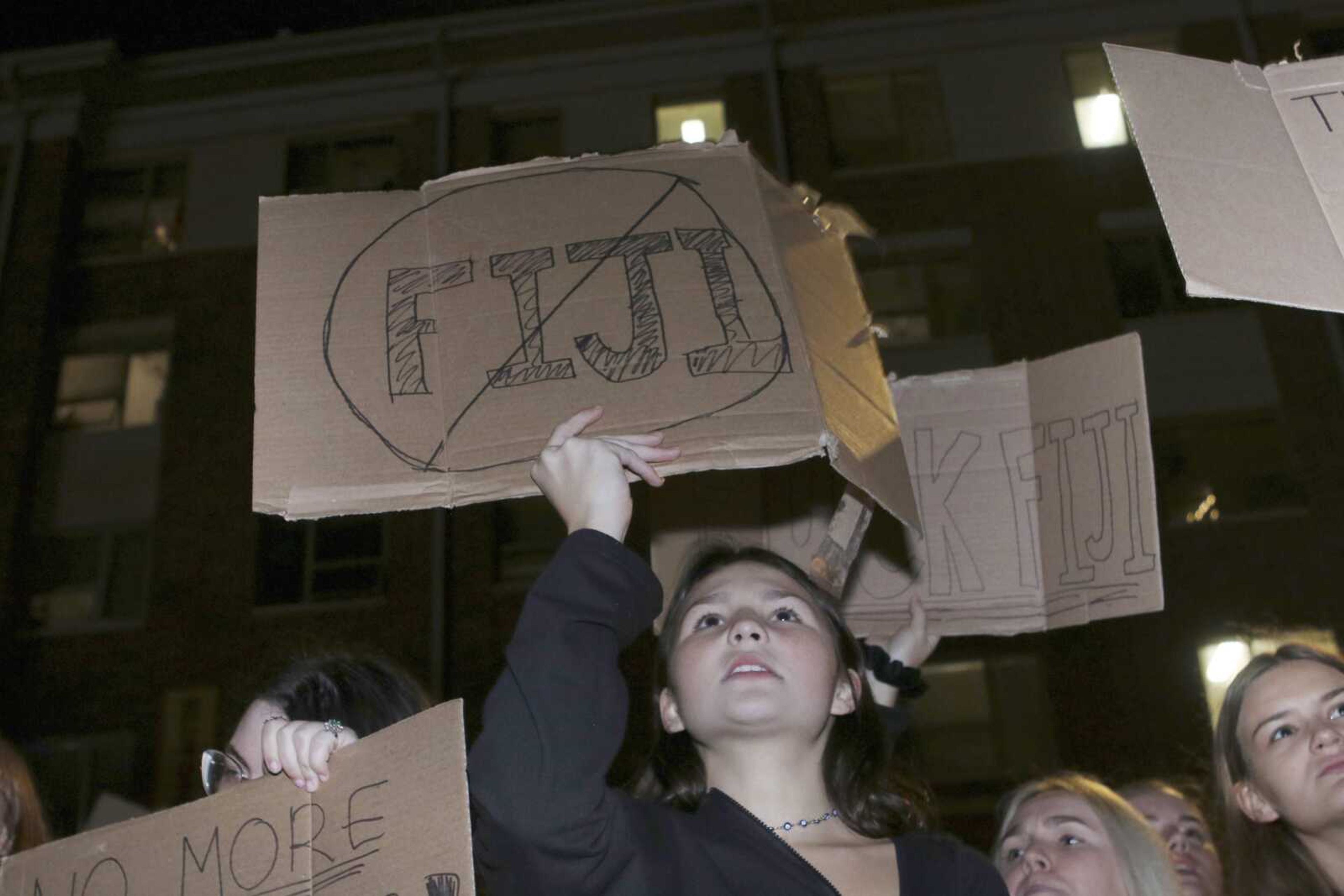 University of Missouri junior Eleanor Wilson holds up a sign during a protest outside of the Phi Gamma Delta Fraternity, also known as Fiji, on Wednesday in Columbia, Missouri. One of Fiji's pledges recently went to the hospital because of alcohol poisoning.