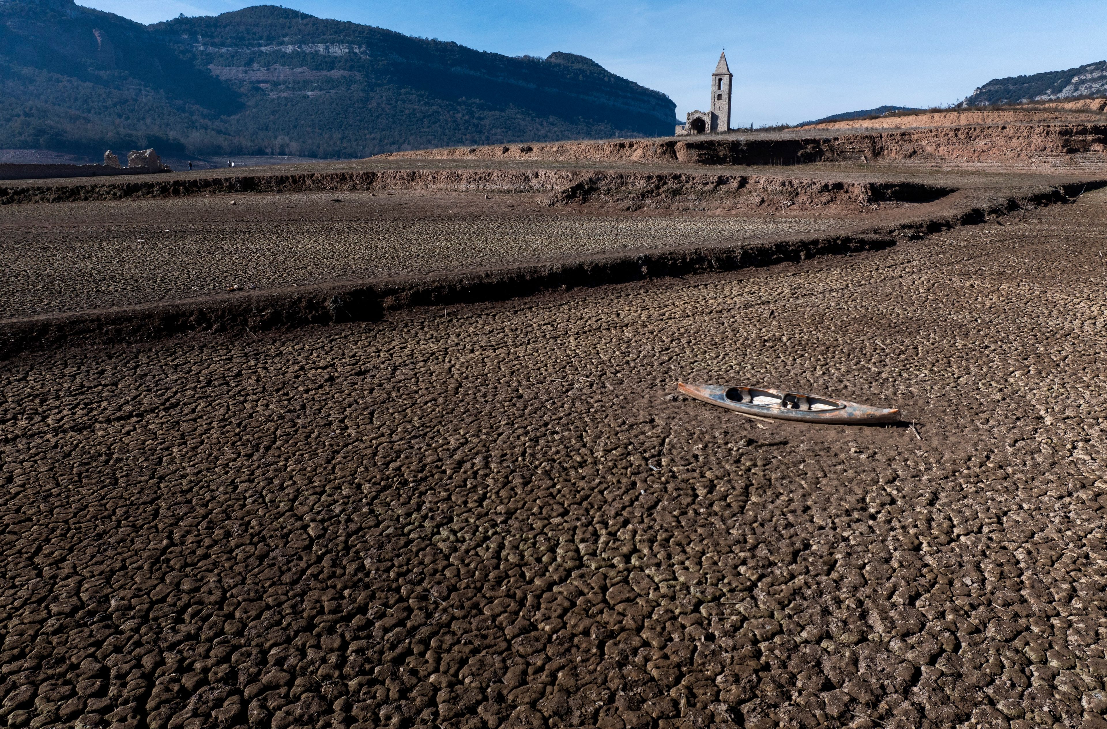 FILE - An abandoned canoe sits on the cracked ground at the Sau reservoir in Vilanova de Sau, north of Barcelona, Spain, Jan. 26, 2024. (AP Photo/Emilio Morenatti, File)