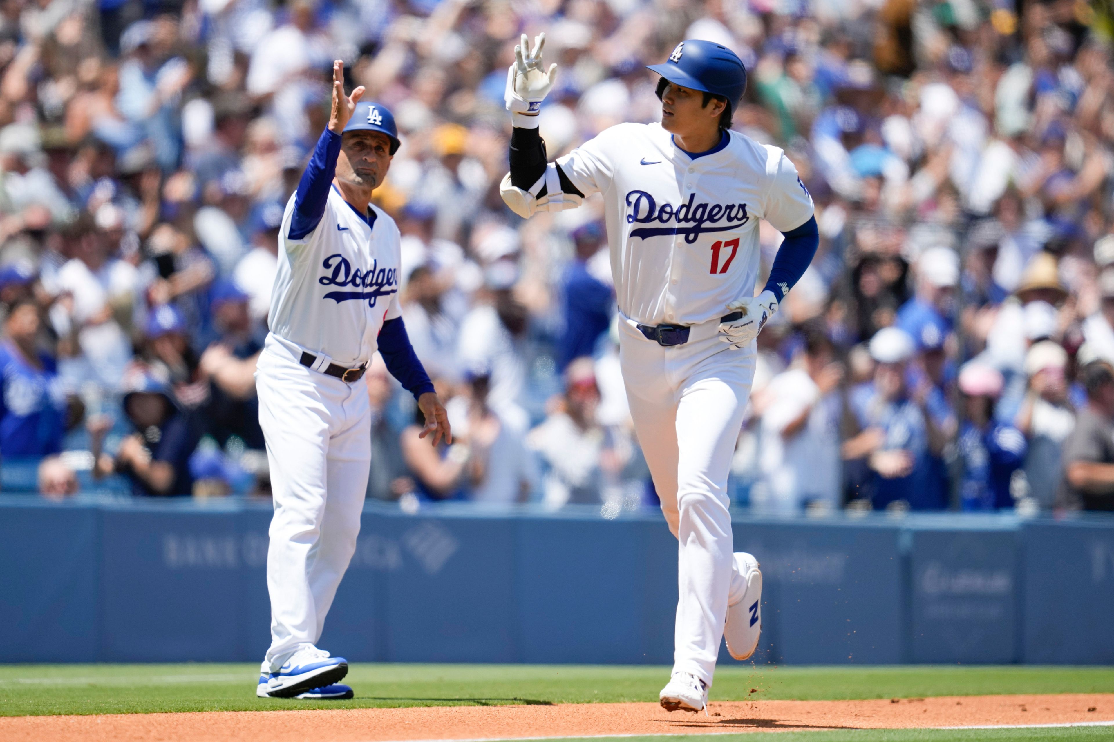 Los Angeles Dodgers designated hitter Shohei Ohtani celebrates with third base coach Dino Ebel (91) after hitting a home run during the first inning of a baseball game against the Atlanta Braves in Los Angeles, Sunday, May 5, 2024. (AP Photo/Ashley Landis)