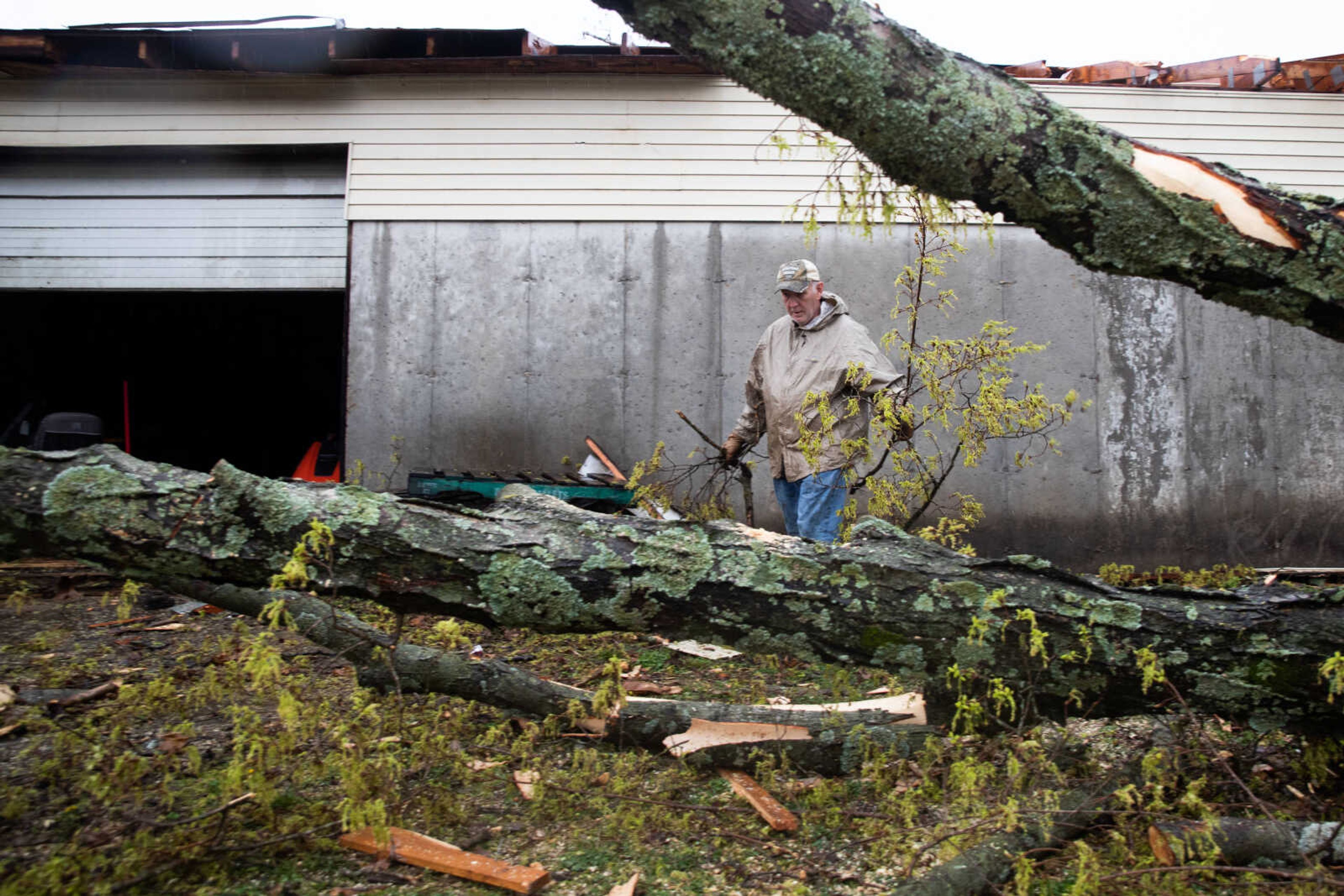 A man clears branches in front of&nbsp;M &amp; G Gas in Glen Allen.