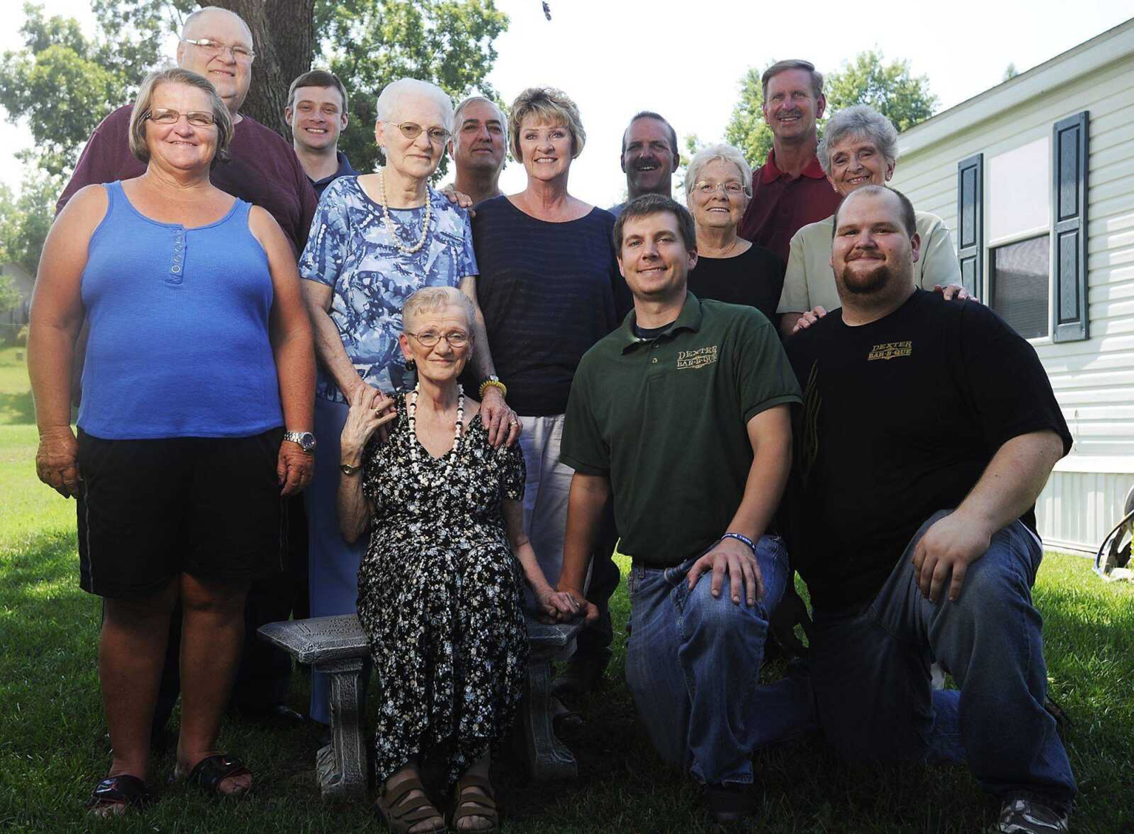 Jean Cook, seated, is surrounded by friends and family July 31 at her home. Front: Cook, Michael Williams and Michael Dixon. Middle: Alice Woodall, Imagene Martin, Linda Fisher, JoAnn Moore and Beverly Hagerty. Back: Ken Martin, the Rev. Nathan Burgell, Bill Woodall Sr., Bill Woodall Jr. and James Banken. (ADAM VOGLER)