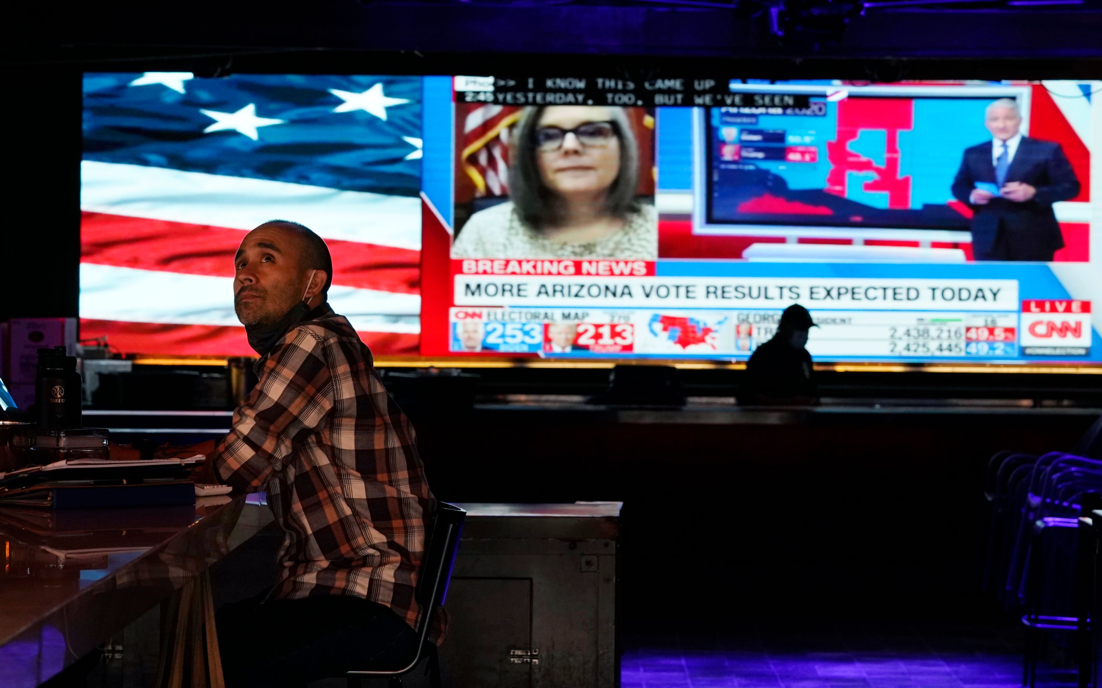 FILE - Alan Zumel, an employee at The Abbey Food & Bar, watches presidential election coverage on a television above the bar, Thursday, Nov. 5, 2020, in West Hollywood, Calif. (AP Photo/Chris Pizzello, File)