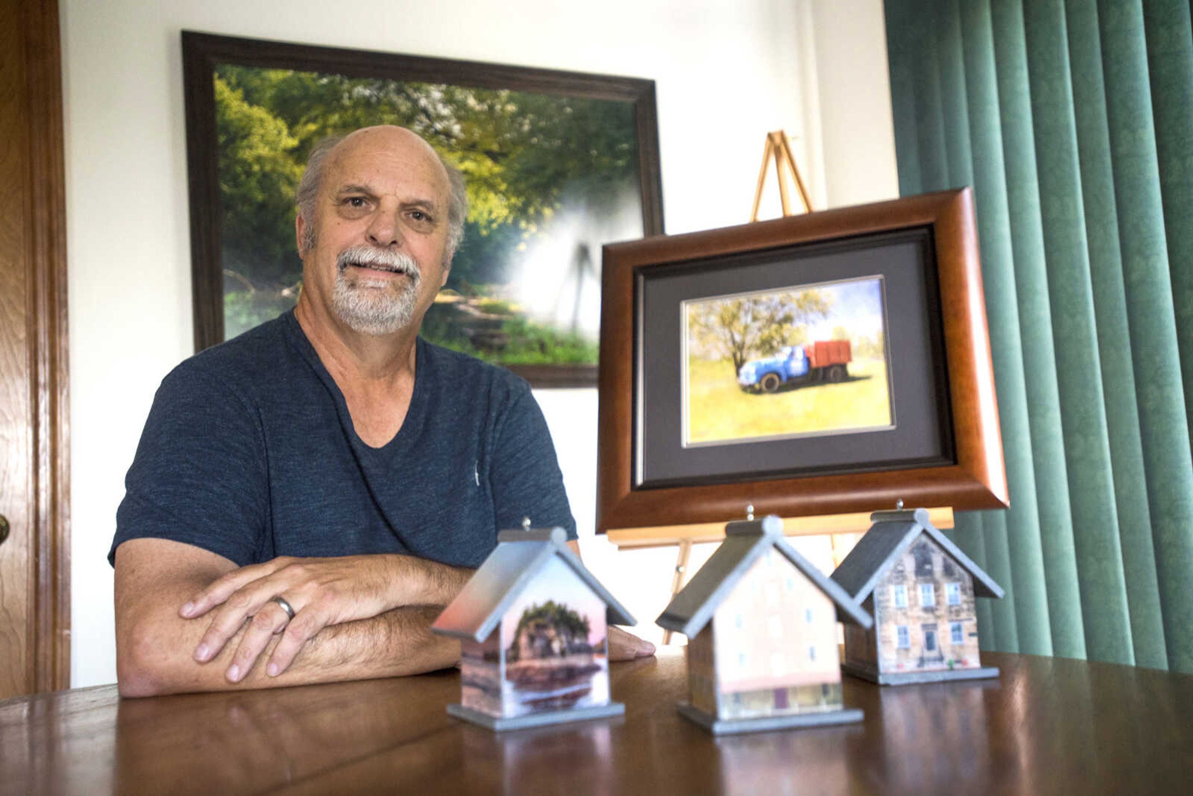 Larry Braun poses for a photo with three of his custom birdhouses and one of his digitally enhanced HDR photographs Tuesday, Oct. 2, 2018, at his home in Benton, Missouri.