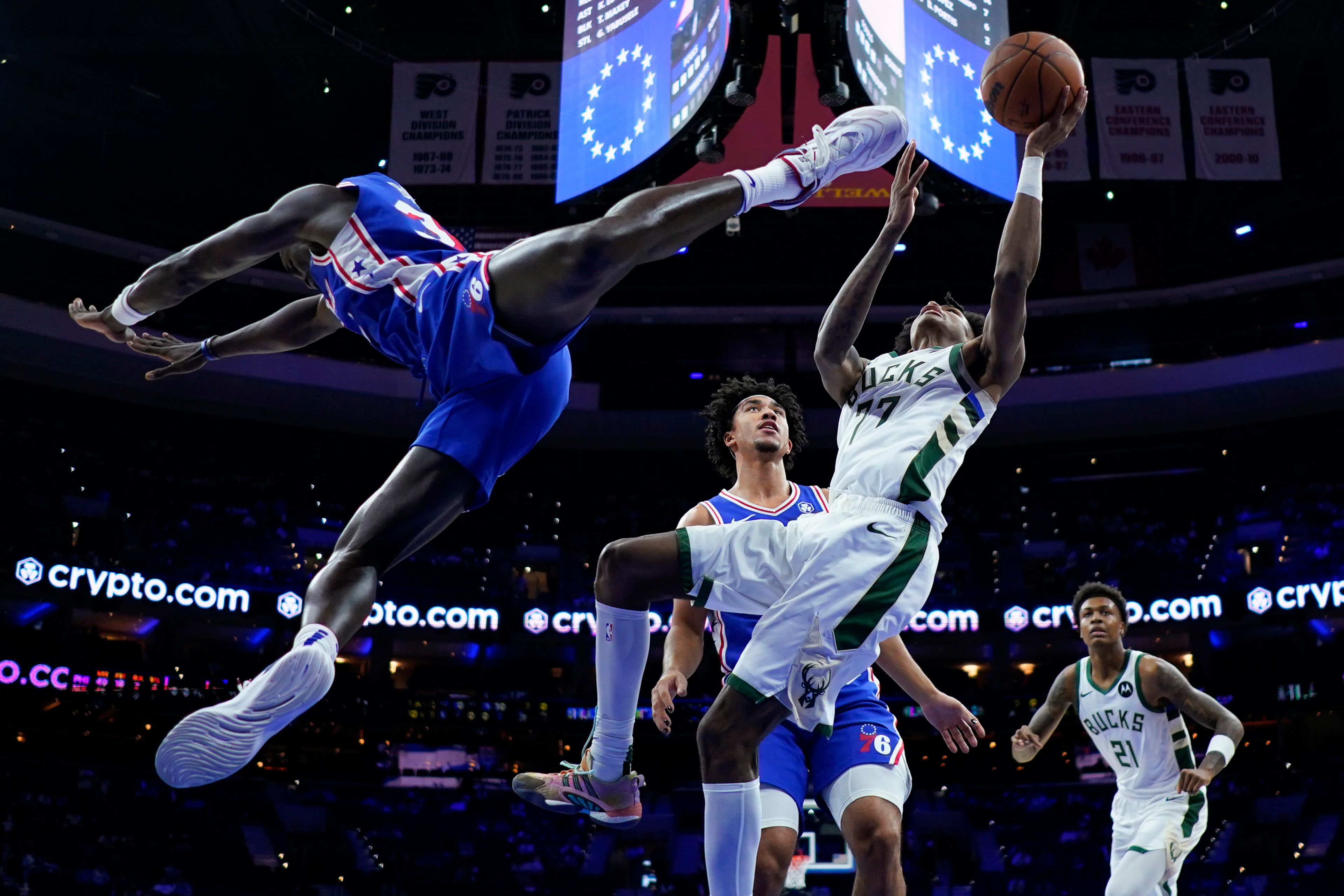 Milwaukee Bucks' AJ Johnson, right, goes up for a shot against Philadelphia 76ers' Jared McCain, center, and Adem Bona during the second half of an NBA basketball game, Wednesday, Oct. 23, 2024, in Philadelphia. (AP Photo/Matt Slocum)