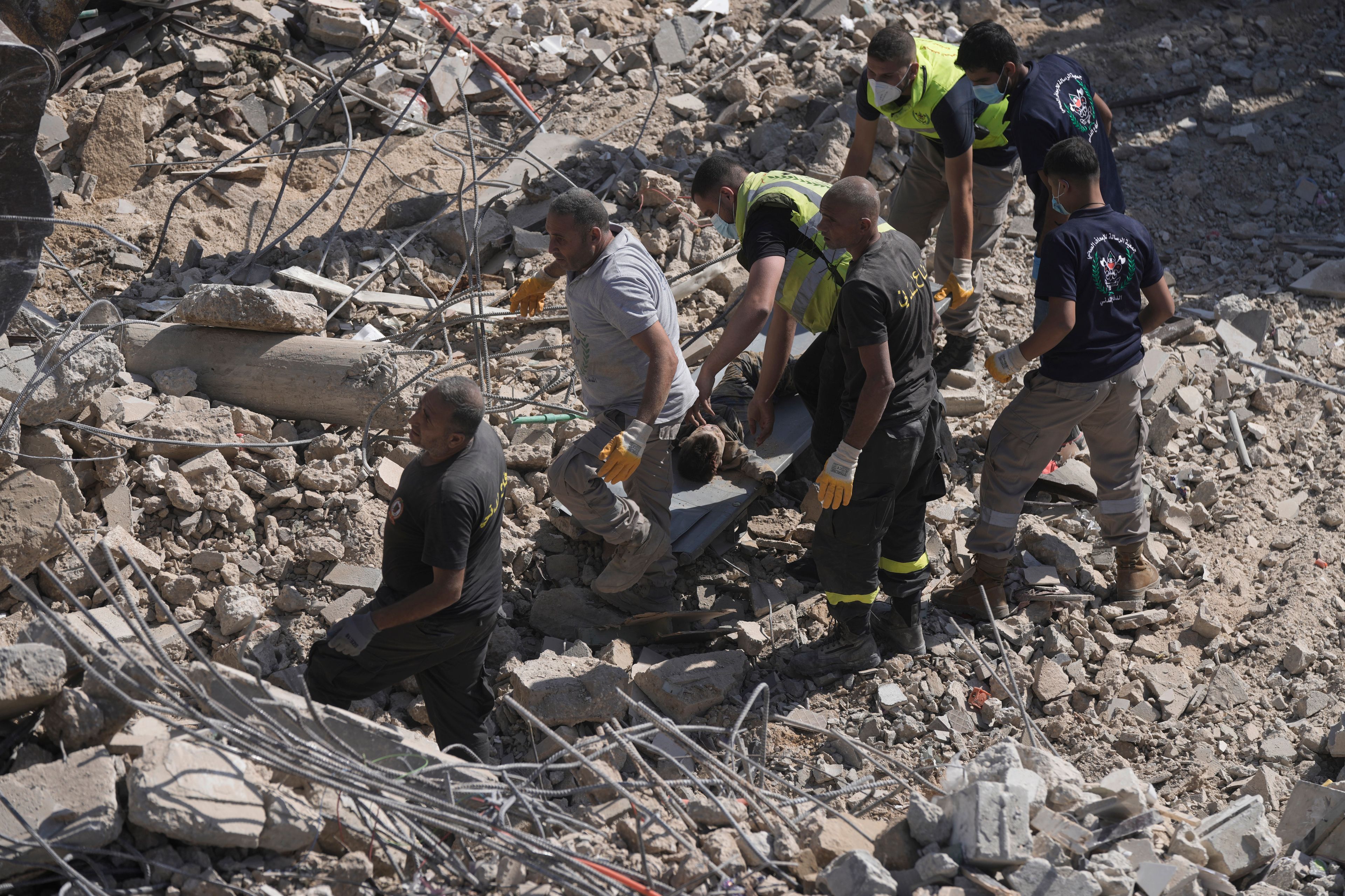 Rescue workers carry the body of a boy who was found under the rubble of a destroyed building that was hit Tuesday night in an Israeli airstrike, in Sarafand, south Lebanon, Wednesday, Oct. 30, 2024. (AP Photo/Bilal Hussein)