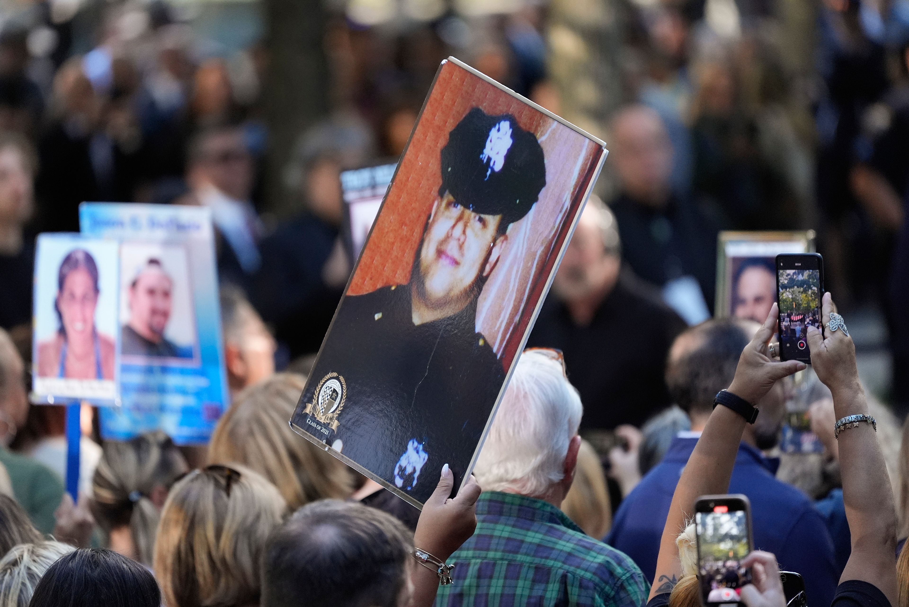 A woman holds up a photo of a New York City Police officer during the 9/11 Memorial ceremony on the 23rd anniversary of the Sept. 11, 2001 attacks, Wednesday, Sept. 11, 2024, in New York. (AP Photo/Pamela Smith)