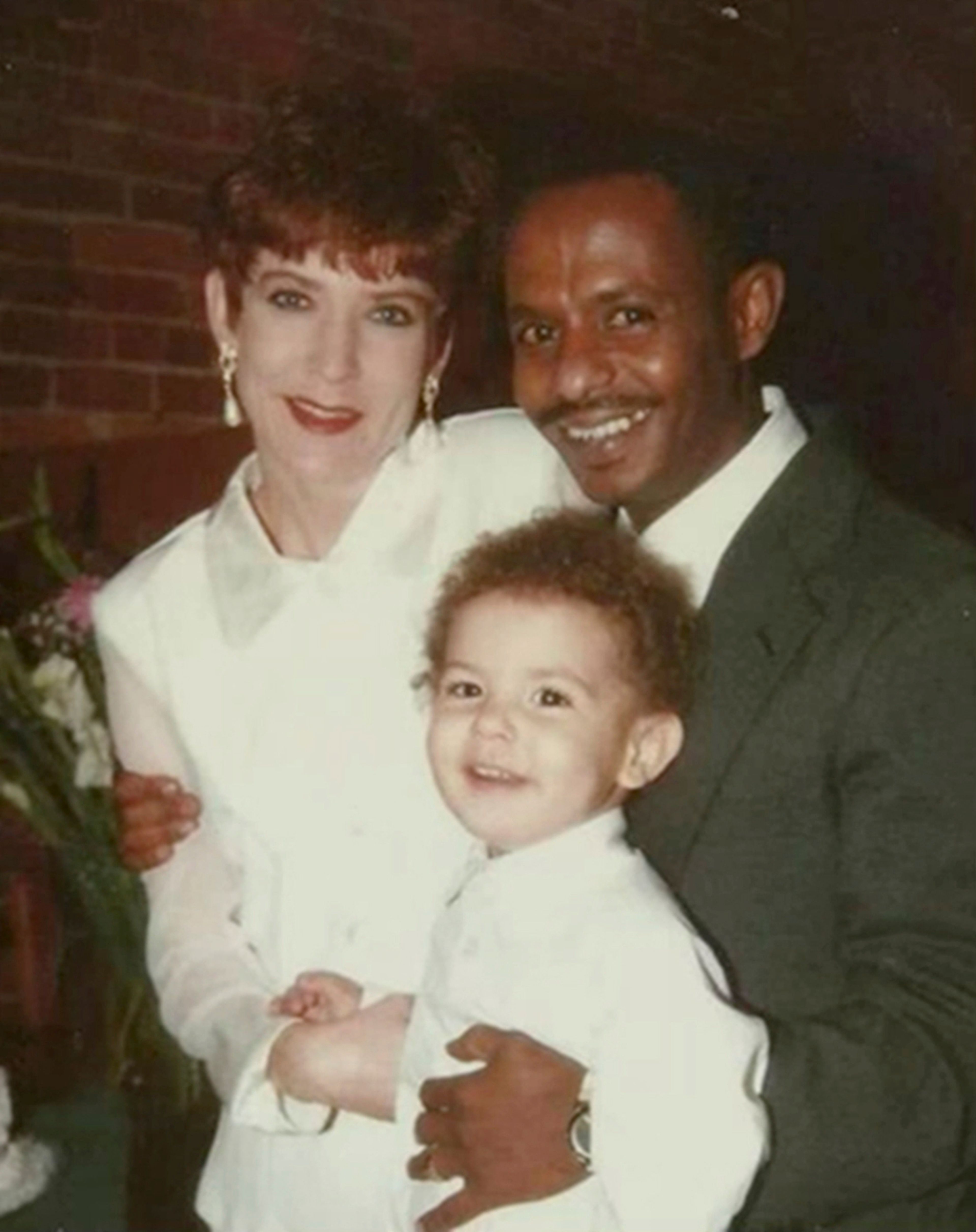 In this photo provided by Mike Davis, right, he stands with his wife, Laura Lynn Davis, and their son, Solomon, in Augusta, Ga, on Feb. 13, 1997. Mike was adopted as a boy an American soldier stationed in Ethiopia who brought him to the U.S. He was deported to Ethiopia two decades ago, and now lives in a room with a mud floor and running water only once a month and even when the tap works, it isn't safe to drink. (Courtesy Mike Davis via AP)