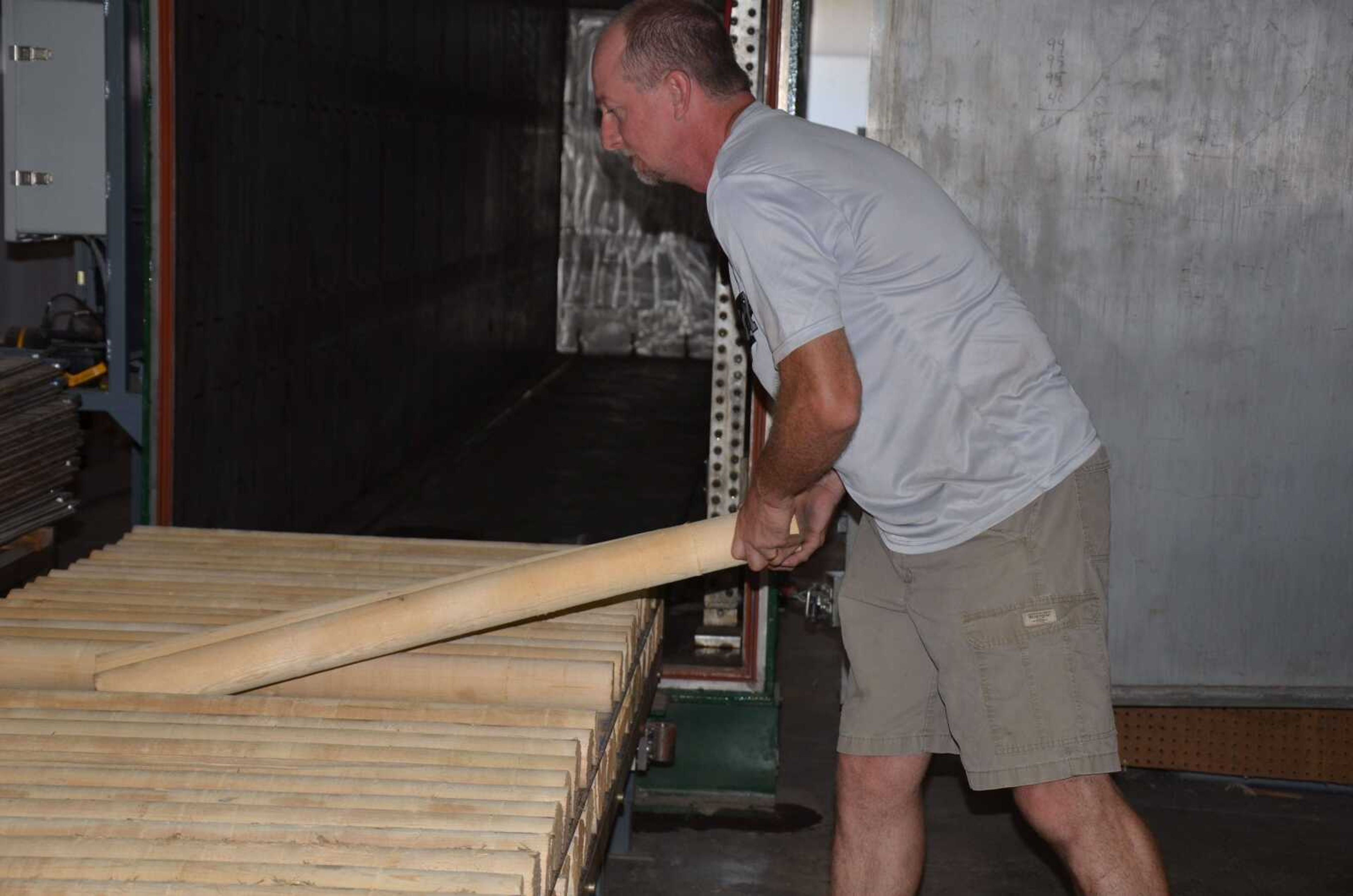 David Keathley of Bernie unloads dowels from a kiln to make bats that may be used in a major league ballpark.